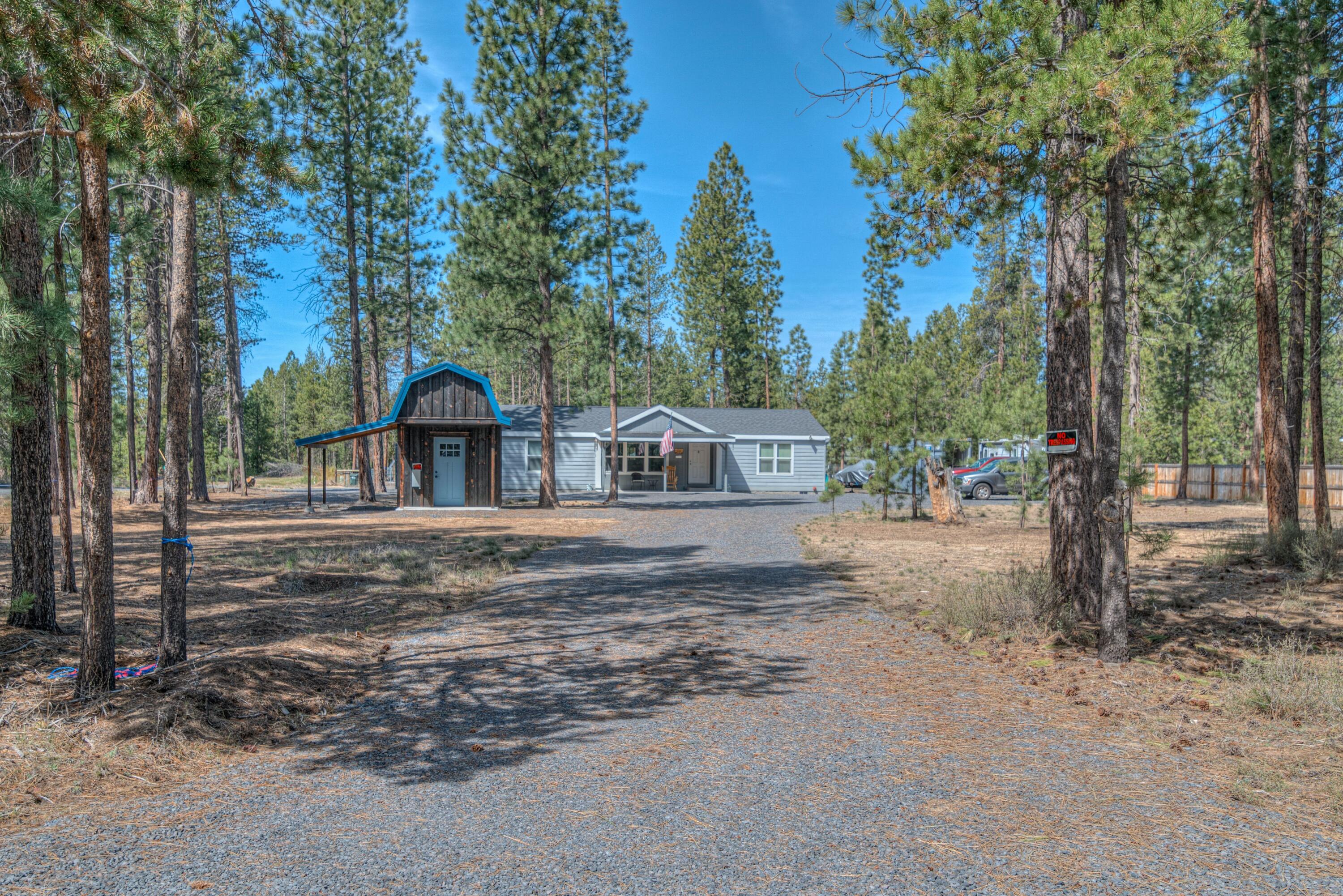 Looking for your dream home in the woods? This private oasis, built in 2022, is waiting for you. With high ceilings and an open floor plan, this home offers spacious living in a serene setting. Each room features a walk-in closet, and the primary bedroom boasts a luxurious tile shower. The lot has been beautifully cleared and fully graveled, with a convenient pull-through driveway and ample space to park all your toys. The home also includes a beautifully crafted patio and back deck, perfect for embracing the surrounding Ponderosa trees. Sit outside, relax, and enjoy the peace and quiet as you listen to the wind rustle through the trees and the birds singing. It's clear this home was built with pride and attention to detail. If you're seeking privacy, comfort, and a connection to nature, this is the perfect place to call home. Don't miss out on this rare gem in the woods!
