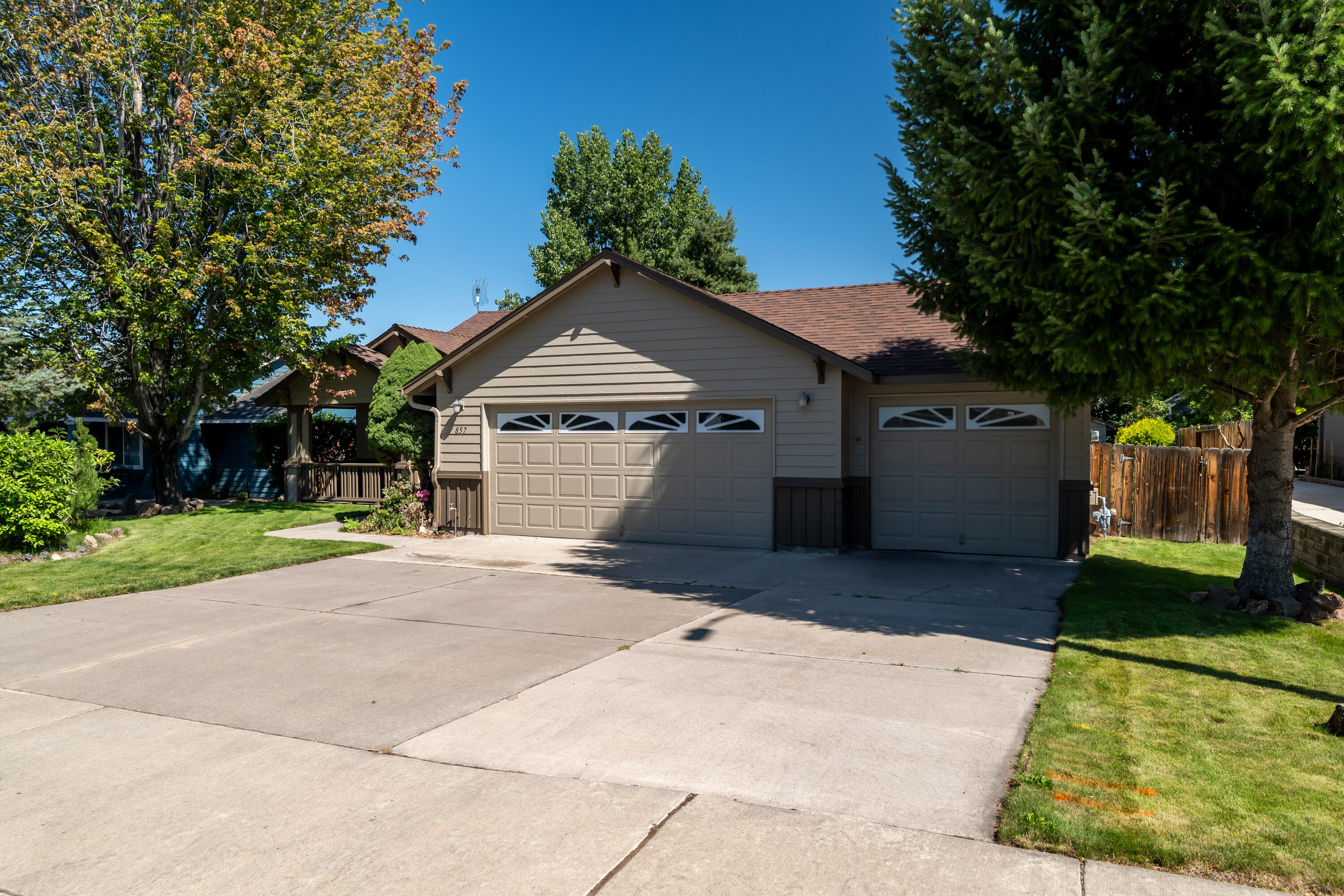 This single-owner, single-level 3-bedroom, 2-bathroom home with an expansive 3-car garage offers tons of potential with a little work - perfect as a first or forever home! Upon entry, you'll find two spacious living rooms with vaulted ceilings and a cozy natural gas fireplace. The kitchen includes a breakfast bar, oak cabinets, and laminate countertops. The large primary bedroom easily fits a king-size bed and features a vaulted ceiling that enhances the spacious feel. It also includes a walk-in closet and a generous bathroom with a seperated water closet area, dual sinks, and a fiberglass step-in shower. Both guest bedrooms are roomy enough for a full or queen bed. The 3-car garage features a 220V EV plug, utility sink, and a finished third bay ideal for storage, a workshop, or a home gym. The exterior of the home and shed were recently painted. Mature trees surround the home, offering shade and a private, secluded backyard atmosphere that's perfect for relaxing or entertaining.