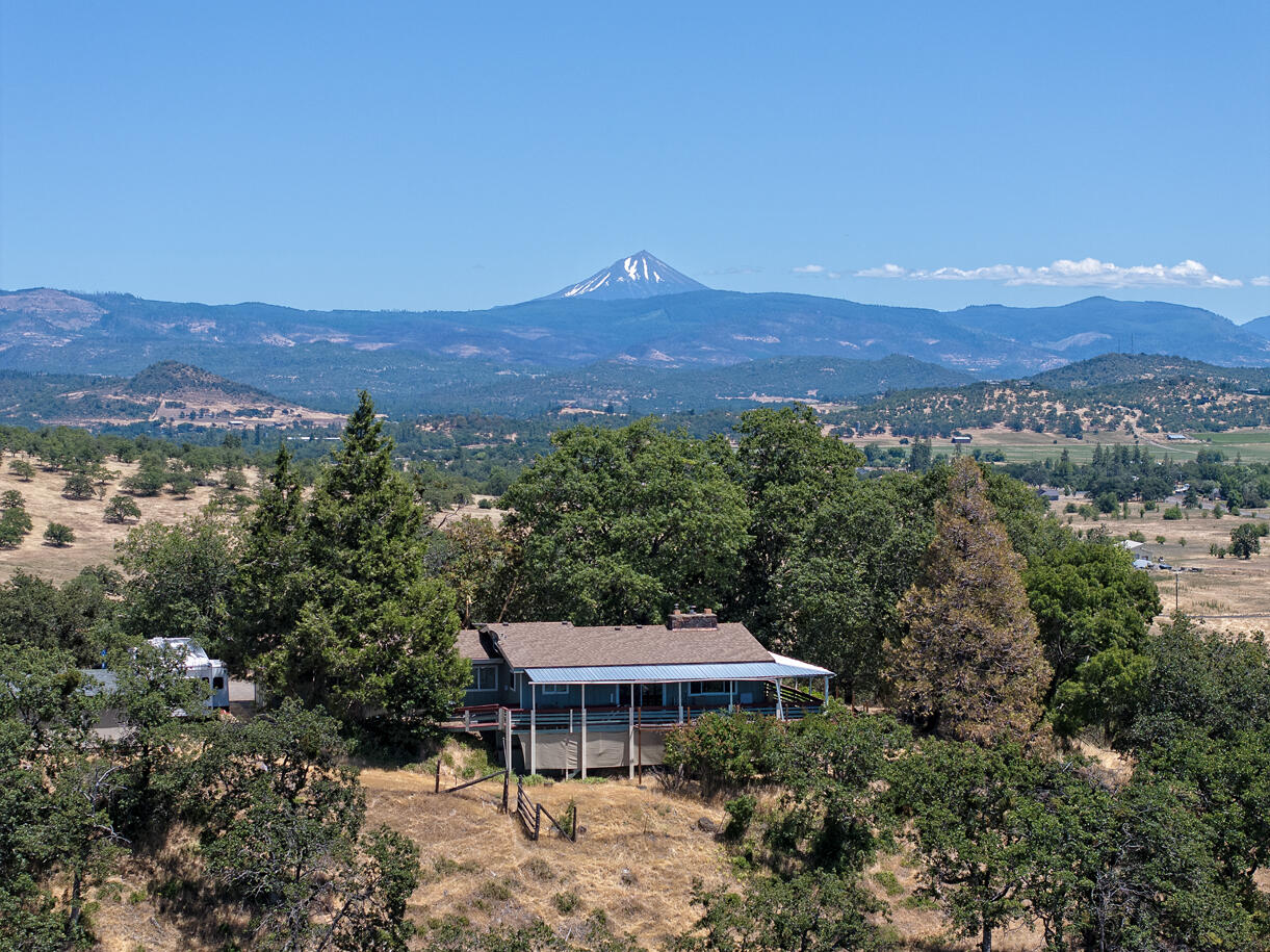 Outstanding views and privacy describe this home on six acres within the city limits of Eagle Point. The 3 bed, 3 bath home features main level living of 3162 square feet and additional daylight basement space. The home is perched on a knoll with views from Mt McLaughlin to the Table Rocks and beyond. You can also see the Eagle Point Golf Club along with many notable landmarks in the town. The home is poised for a remodel to make it your own. The property is nicely positioned for future development as recent subdivision activity is approaching this parcel. The home is served with city water. Additional outbuildings include a shop and barn. Value in location, views, existing structures and future development potential. Any purchaser to perform their own due diligence regarding uses and future development options.