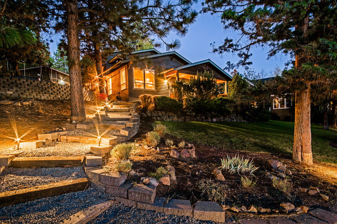 This remarkable home has undergone extensive upgrades, combining an impressive grandeur with a welcoming ambiance. 
Situated between the conveniences of Bend's west side and a world of outdoor adventures.  Bike to Phil's trailhead, beat traffic to Mt. Bachelor, or simply step out your back door into a 40-acre park. . Resting on a .41-acre sloping lot, it offers a private retreat among the trees.  As you enter, you're greeted by a cozy living room featuring a stunning stone fireplace and an attached den. The updated kitchen is spacious with a large pantry and dining room. On this level, you'll also discover a spacious room with an attached full bath, could be an office or bedroom.  The primary bedroom is drenched in natural light.  It has a large bathroom and generous walk in closet.  Up a half-flight of stairs you'll  reach the two guest rooms and full bath. The backyard is a haven, featuring a hot tub, treehouse, 2 terraced yards, and a fenced dog run. This is a Bend Dream Home.