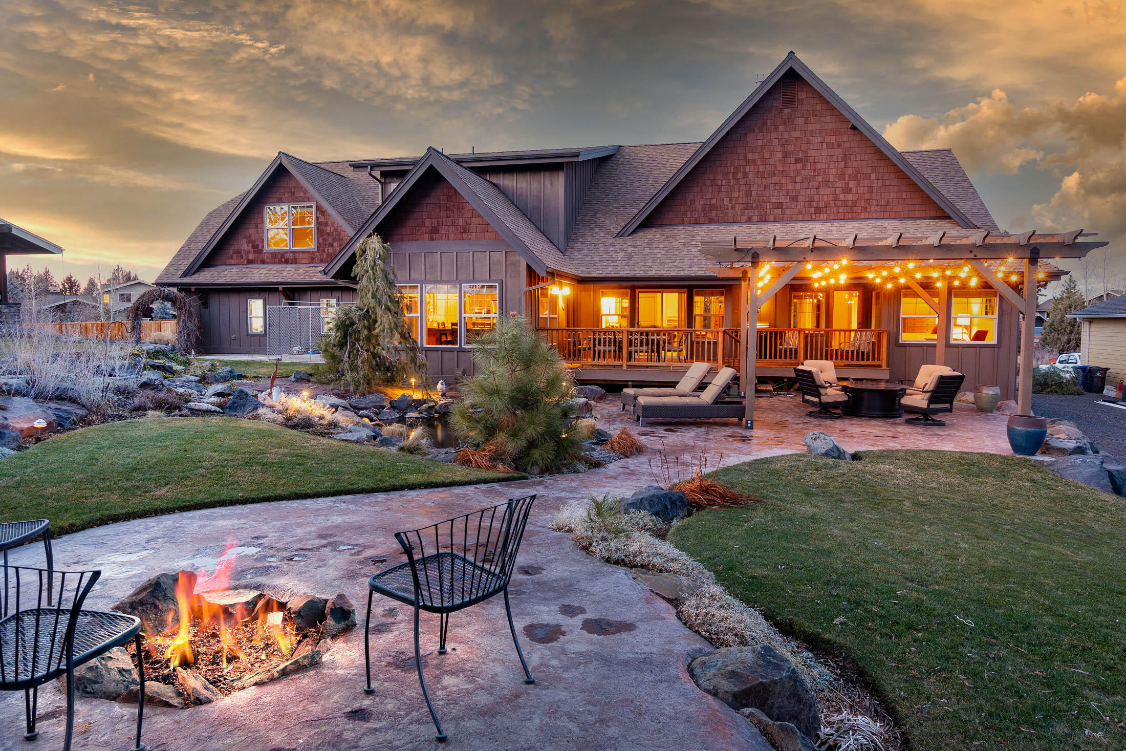 Jaw dropping entertainer's home in desirable Silver Ridge Neighborhood. What home in beautiful Bend offers both a primary suite along with an additional guest suite on the main floor? This gem does! The luxury home, w/ cathedral vaults, is appointed with a chefs kitchen, main level executive office on the East wing along with the master suite. Open floor plan ties all this in along with dining area and epic expansive outdoor living with pergola cedar deck and enormous stamped concrete featuring a rear built in fire pit & year-around water feature pond stocked with ancient Koi fish. Oversized triple truck garage, five comfortable bedrooms plus a bonus gaming room featuring projector media & drop down big screen.  Private section of town with a great feeling of separation (mountain views) and independence. Superior luxury home with premium finishes throughout on a large lot; come make this property yours today!