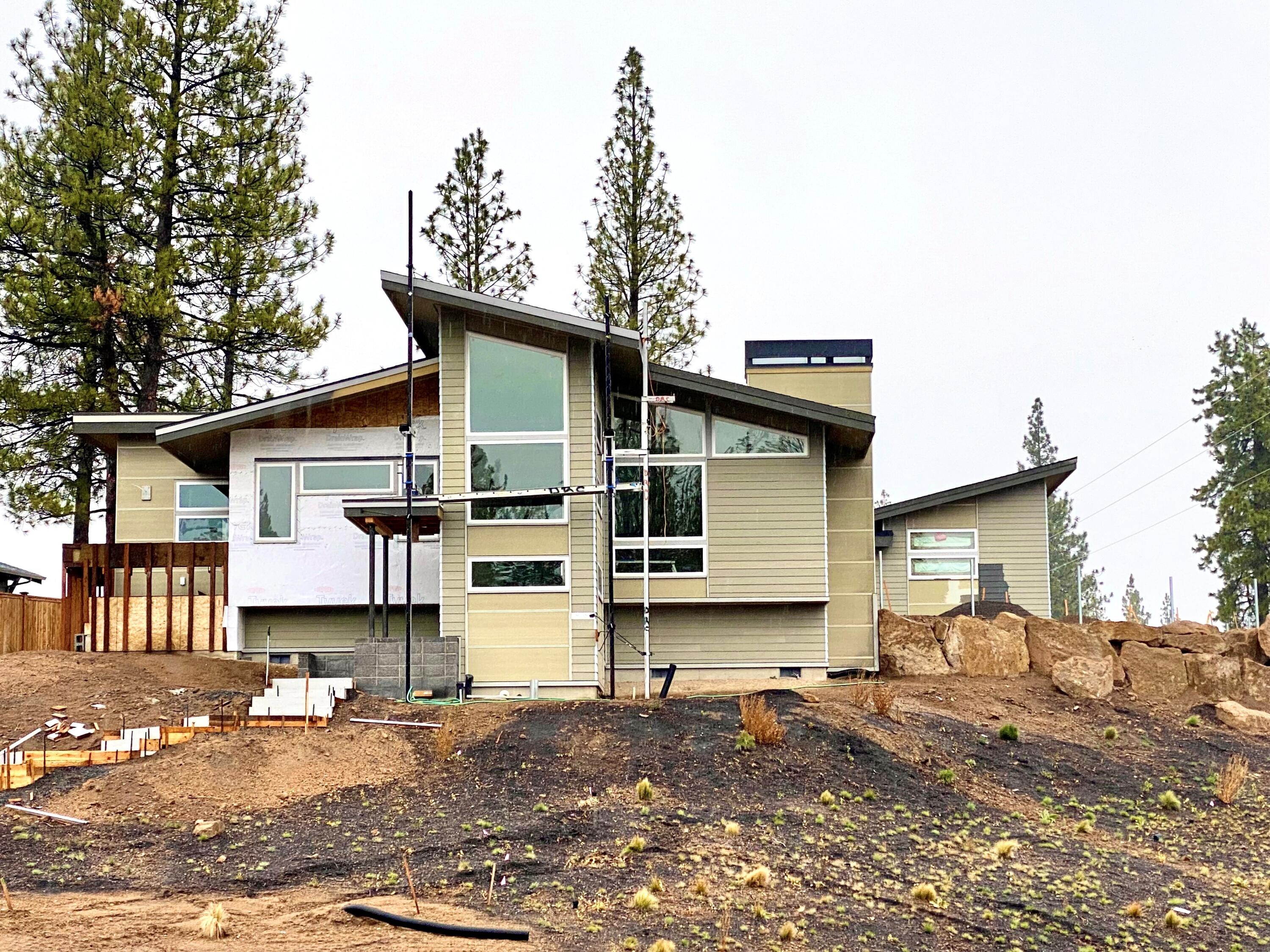 Lot 1 in Discovery West sits on a bluff and has exceptional privacy and a mountain views. Hackbarth Builders has constructed a Mid Century Modern style and plan fit for any buyer. The 3 bedroom 2 bath, single level floor plan takes full advantage of the vaulted ceilings and windows and lets so much natural light in. The kitchen features custom cabinets and solid surface quartz counter tops as well as JennAir appliances and high end fixtures throughout. The patio provides an expansive outdoor space for entertaining and relaxing, complete with a roll up door to a 14'x15' toy room/storage room that connects to the patio and garage. The 3 car garage is perfect for the Bend
life, one of the bays is an 11' RV door. This neighborhood was thoughtfully designed to provide residents with conveniences like restaurants, shops, parks, schools and trails. Pedestrian-friendly streetscapes and patios invite neighbors out of their homes, resulting in less reliance on vehicles.