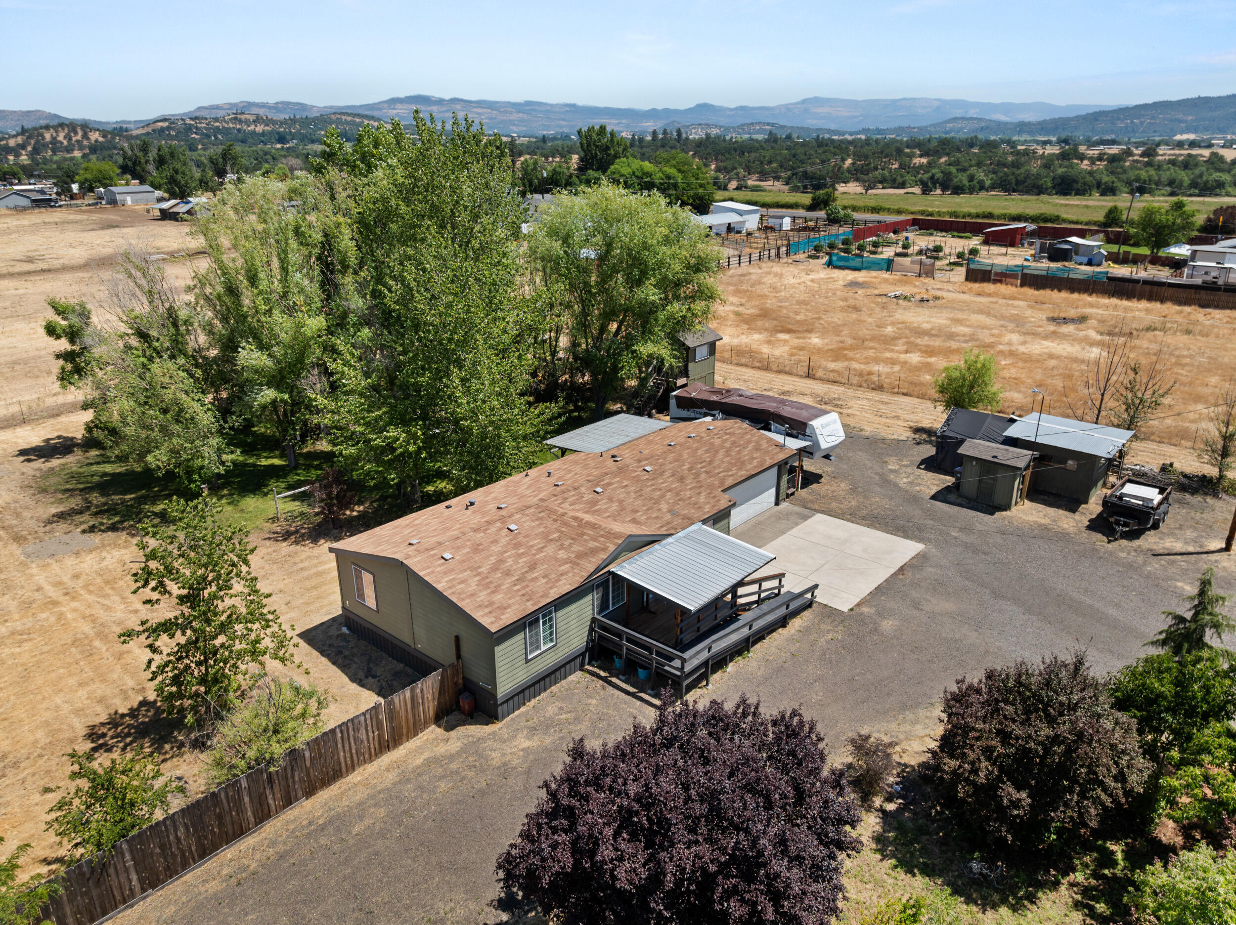 Well maintained home on 2 full ACRESof pasture land, a koi pond with waterfall, fruit trees, garden boxes, multiple sheds, fencing and cross-fencing, and VIEWS. This lovely home has some updates throughout, such as laminate flooring, paint, and a 2-year old detached ''granny unit''. This detached unit is 400 sf with a bedroom area and walk-in closet. It's fully finished with lighting, heat/ air and electricity but the garage door was left in tact and could be converted back if a 2-car garage is so desired. This space has a hallway with a refrig that leads into an RV that the home owners utilize as their kitchen and bathroom, so this property was intentionally set up to house 2 generations. The RV can be included. The land has a multiple RV hookups w/ dumps, is gated with 2 driveways. Make this private and pretty place yours!
