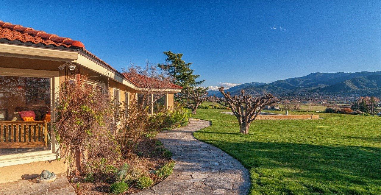 A phenomenal Estate property with unparalleled 360 degree views overlooking the city of Ashland, the Valley, including Mt Ashland. The two single level homes on this Estate are nestled on 36+ acres of lush, private, irrigated land. The beautiful main home is sunny and filled with light. Several of the rooms open to the outdoors where the trellised patios, inviting pool, hot tub, Koi pond and waterfall beckon. A gracious dining room enjoys amazing views and can seat ten people. The chef's kitchen can accommodate more than one chef. The Master Suite has been beautifully renovated including the spa-like bath, with a see-through fireplace. A charming 2 bedroom cottage is privately located on the other side of the property.