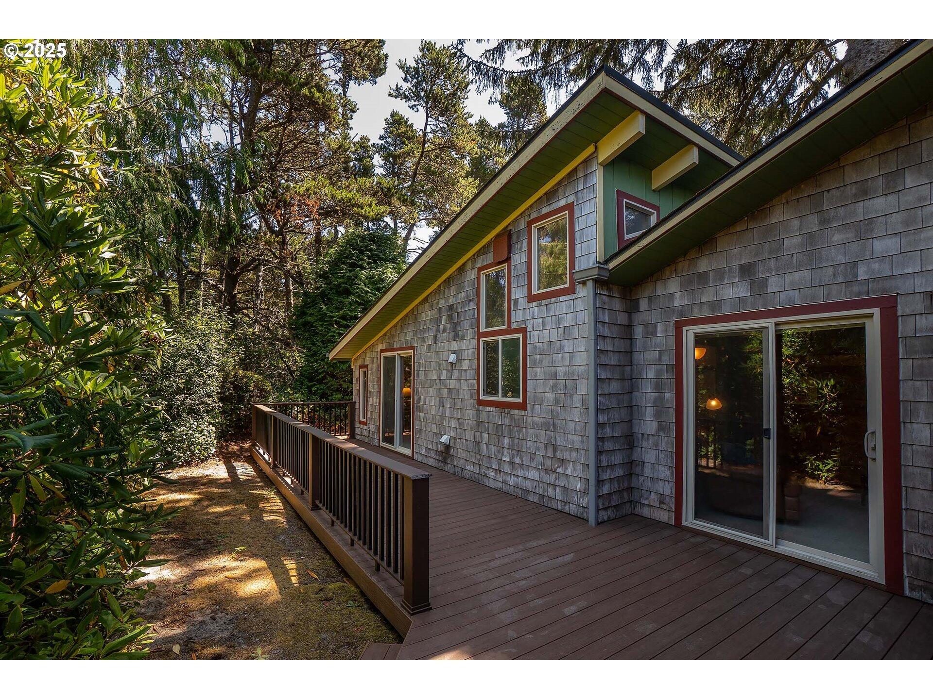 Charming and cozy beach retreat in the desirable Heceta Beach area—just two blocks from the sand! This home isn't like the others—you'll feel it the moment you walk in. Cedar shake siding, gutters, a spacious low-maintenance deck with covered entry, and a rare detached garage with storage, room for workshop, and windows. Lot features room for RV/boat parking plus extra driveway space. Two tax lots total .19 acres on a wooded, level lot with cedar, fir, rhododendrons, and native plants offering privacy. Inside feels like a true cabin getaway with vaulted ceilings, cedar paneling, and solid wood beam accents. Living area & primary bedroom open to the deck. Loft/bedroom adds extra sq ft. Full bath features a vintage tub/shower and high ceilings with windows to keep it bright. Detached bunkhouse/studio with a half bath for added versatility. New roof on main area of home & bunkhouse/studio. Peaceful full-time living or great investment just steps from the ocean!