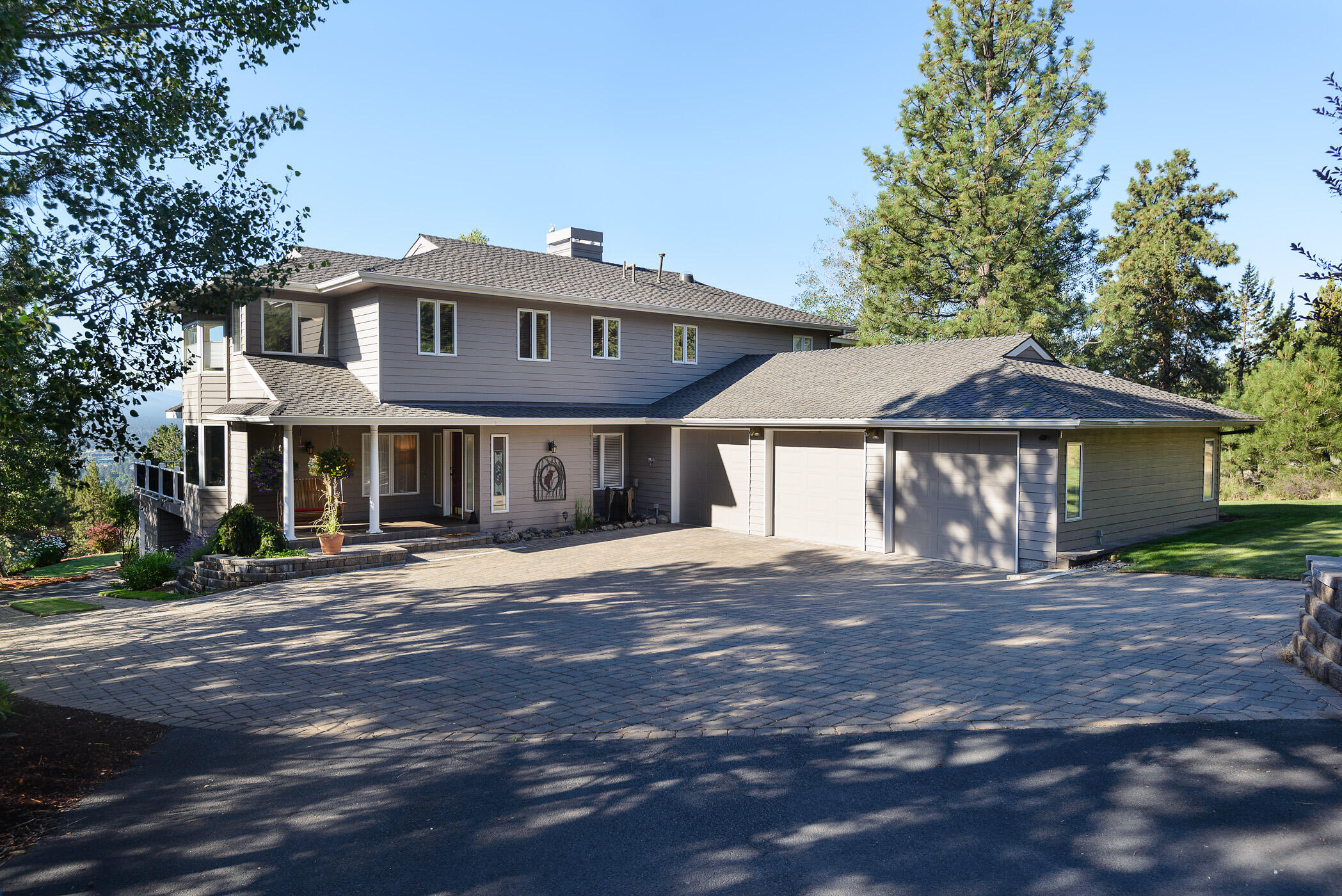 Privacy abounds in this gorgeous NW Bend Home perched on over 1 acre on the hill. The well appointed features present a warm, inviting, partially updated home with a well designed kitchen with butler pantry is open to the dining room and great room with built ins, a gas fireplace and abundant windows brining in sunlight and  views. The main level features plenty of room for entertaining, both kitchen area dining, a formal dining room and an office/den. Take in the south views while enjoying your morning coffee on the huge deck. An O/S 3 car garage is attached to main level. Upstairs is the Primary bedroom, 2 baths and two other bedrooms. Downstairs is a 4th bedroom, bath and access to an O/S one car garage and shop and also a wine tasting room and locked fireproof closet. This home and property have character and so much to offer. Lots of room to garden.