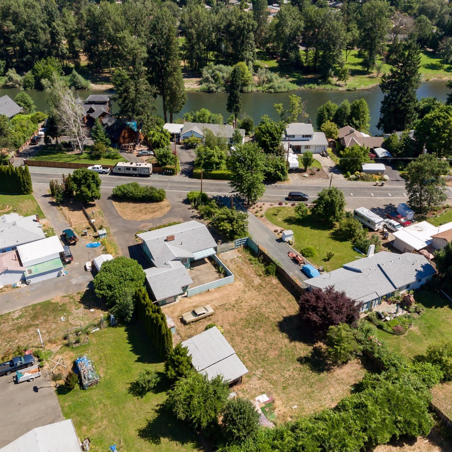 Investors Dream Zoning - Hard to find R-2 zoning build 2-3 homes on the lot OR bring in City Water and build 6 units (per seller research at the city). Cute fixer with Butlers Pantry, large closets, large living room, cozy fireplace, hardwood floors, 2 wells, gated entry, approximately 4 year old roof (per seller). Large shop with tons of parking with room for any size RV. Stones throw from the Rogue River, walk to the park right on the Rogue River.