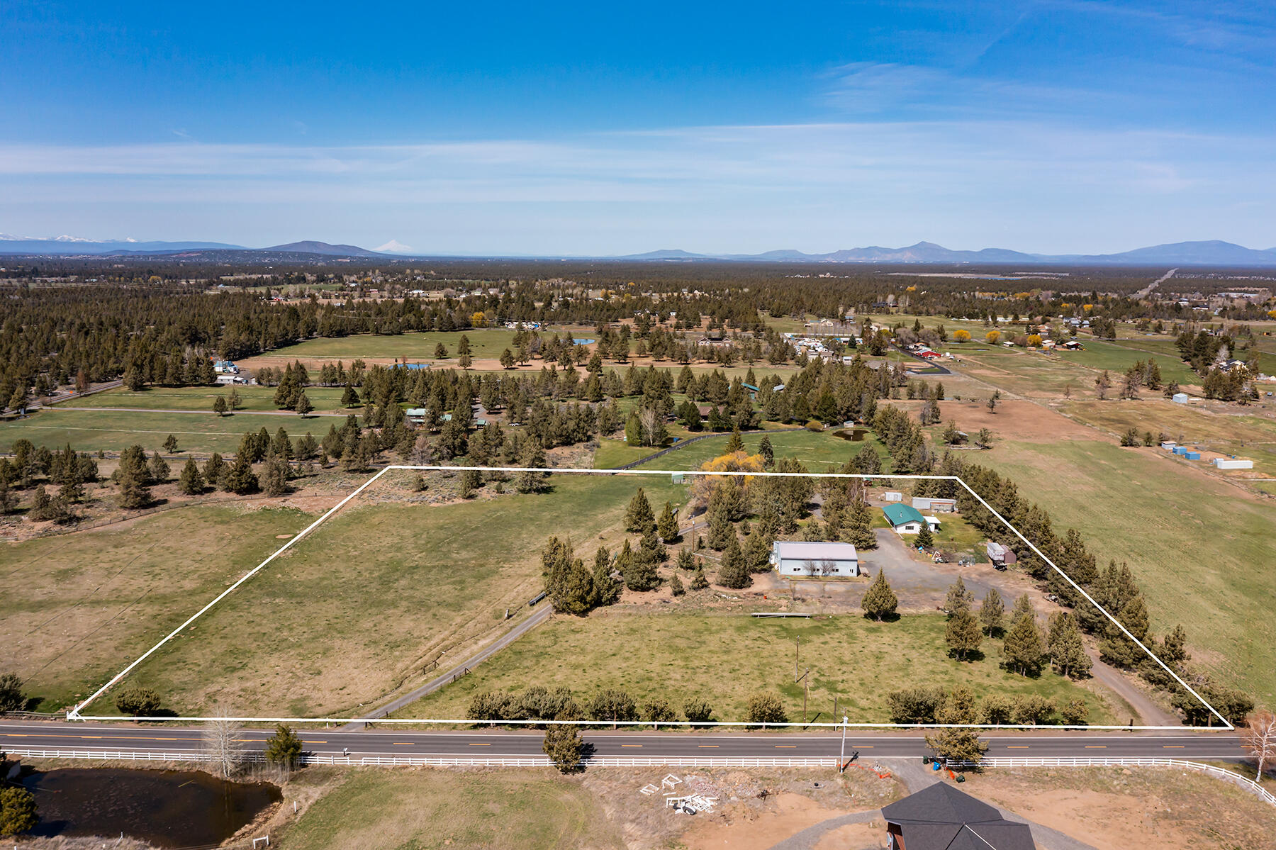 Location, Location, Location! A rare opportunity to acquire this almost 10 acre property just out of Bend's city limits close to the Urban Growth boundary!  Gorgeous Cascade Mountain Views and Pilot Butte greets you as you are enjoying your fully fenced acreage with 6 acres of irrigation plus a pond!  The house offers 3 bedrooms and 2 bathrooms - freshly painted and new carpet!  There's a nice sized utility room that leads you into a enclosed garage/flex room.  A 64x60 Shop that includes office space, bathroom, plus a separate room will hold any equipment or offer adequate space for any hobbies you might enjoy.  RV parking that has full hookup!  Hobby Farm, Build your dream house, make improvements to the main house - the lists goes on as to what this property can offer now and will be a great investment with potential future development opportunities.