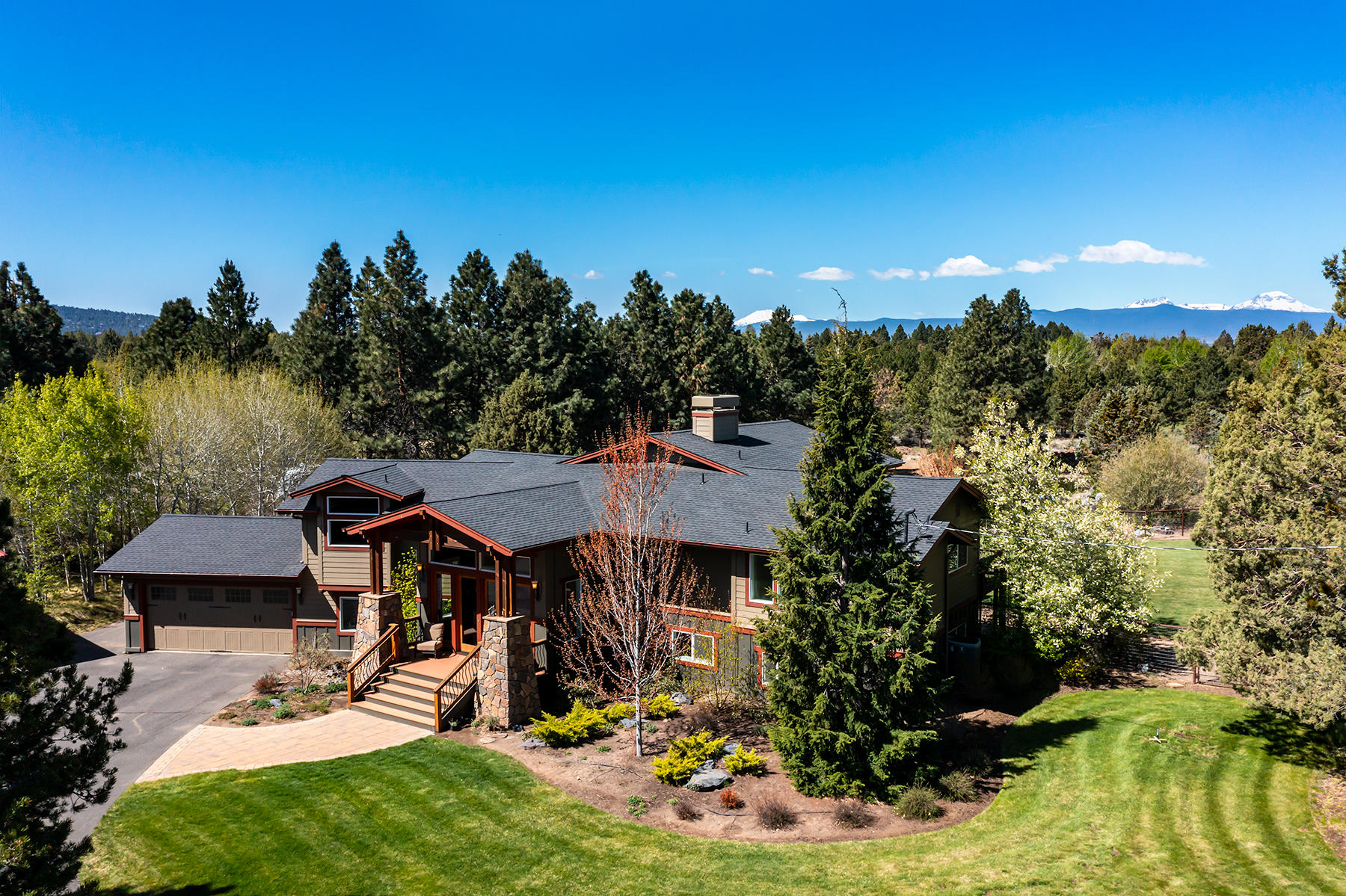 Stunning home on 5 acres in Tumalo, just outside of Bend with mountain views. Completely remodeled in 2008. Spacious open great room with vaulted ceilings, wood floors, floor-to-ceiling stacked stone gas fireplace with built-ins and extensive views that overlook the pond, waterfall, lush green lawn, and the mountains. Large kitchen with full tile backsplash, 6-burner Aga Stove with double ovens, custom cabinets, island with breakfast bar and walk-in pantry. Master and office on the main level. Large master with his and her closets, double vanity, tile shower & soaking tub with tile surround. Downstairs features a family room with gas FP, 3 bedrooms  2 baths. One bedroom could be a 2nd master with a bath across the hall with shower and soaking tub. Wonderful deck on main level and paver patio below with hot tub. Tennis court, fenced and cross fenced, 3 acres of Swalley irrigation. Attached garage plus huge insulated and heated 5-door shop with RV storage, upstairs office and loft.