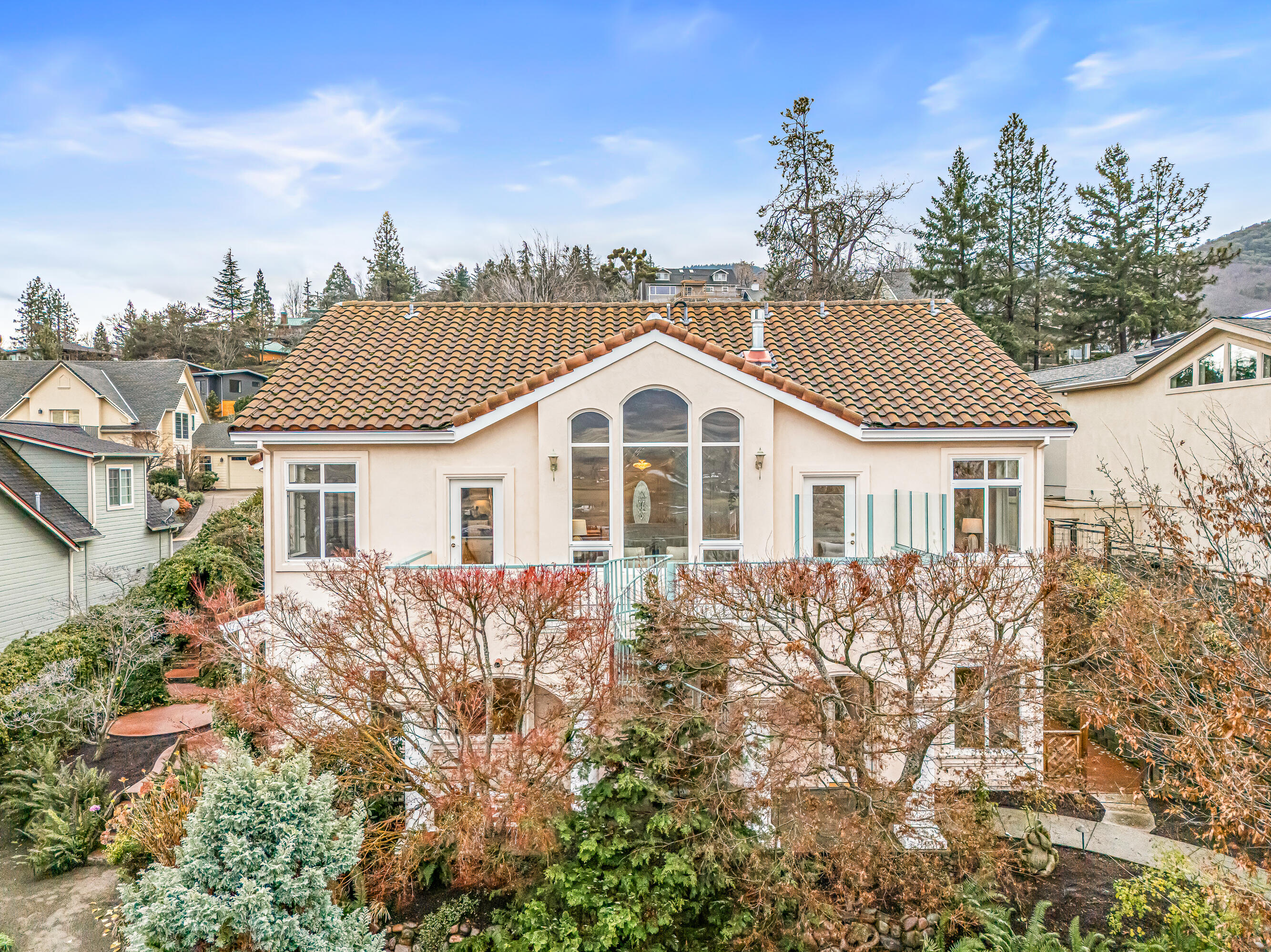 Enjoy the sweeping panoramic views from this 2890SF Mediterranean-style villa on the hill! This home, custom-built in 2001, features primary-level living with three bathrooms, a kitchen, a living room, and an artist/office/practitioner space with large windows, skylights, and a separate entrance. From the living room, dining room, kitchen, and the primary bedroom, the vaulted ceilings and large windows create an open, airy feeling to enjoy the incredible views and a sense of privacy. Be sure to take your shoes off and feel the radiant heat floors! Downstairs, you will find 2 bedrooms,1 full bathroom, and an additional living area with a separate entrance that would make a great multi-generational setup or rental ADU. The backyard has beautiful mature landscaping and is a peaceful retreat with a water feature, gas fire pit, automatic lighting, and garden beds. 2 Laundry hookups are another bonus!