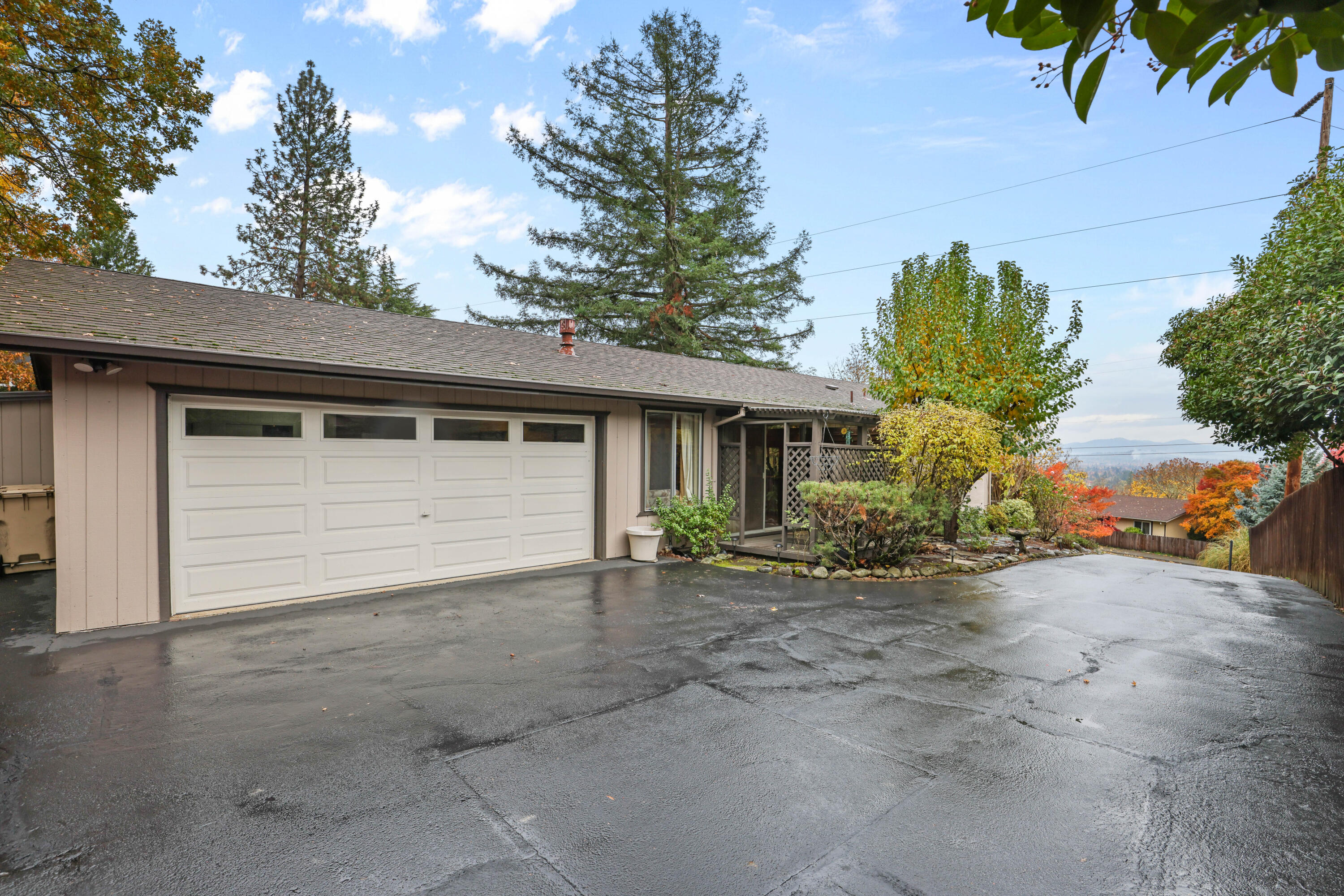 Enjoy peaceful mountain and valley views from the spacious front deck of this charming ranch-style home. Set on a gentle rise, this single-level home offers 2 bedrooms, 2 full baths, and 1,362 sq. ft. of comfortable living space. The inviting living room features a brick-accented gas fireplace, and the bright kitchen includes a large breakfast bar, ample cabinets, and a nearby laundry area with pantry. A cozy family room with a second gas stove and a dining area that opens to a covered back deck provide perfect spaces to relax or entertain. The primary suite offers lovely views, dual sinks, a step-in shower, and a linen closet. Enjoy central heat and air, an oversized finished 2-car garage with storage, and a landscaped 0.21-acre lot with garden space and paved driveway. Conveniently located near town, parks, and schools with easy access to I-5.