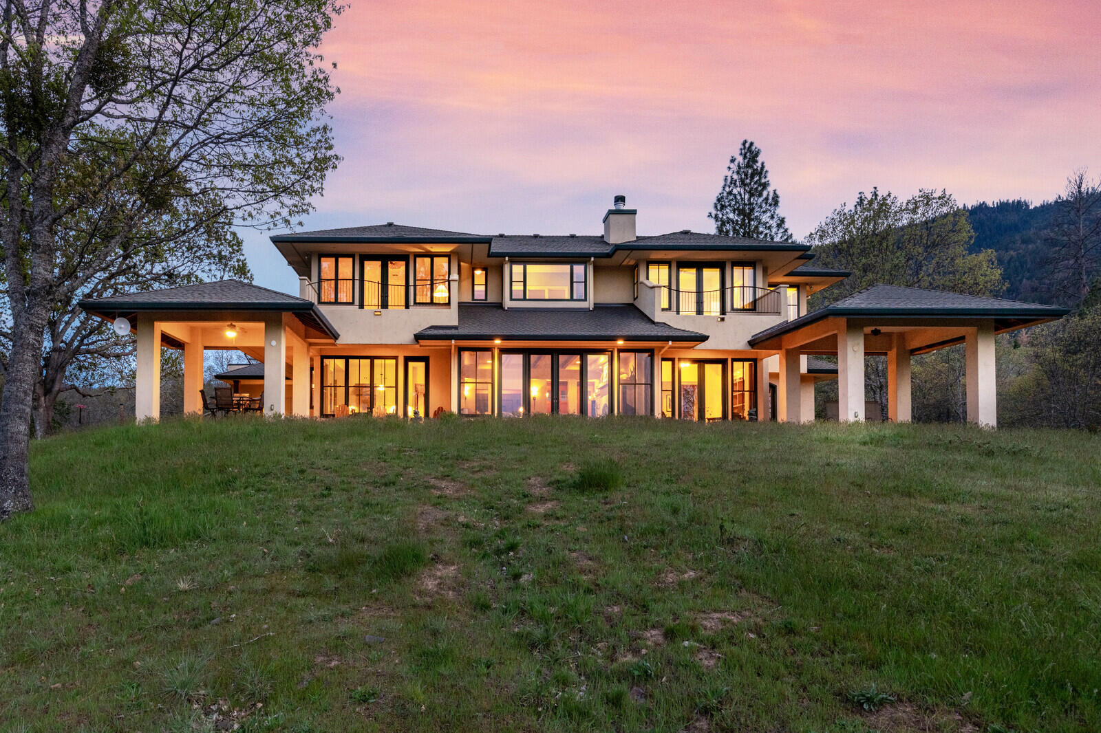 An exquisite property offering stunning views of the surrounding mountains, bluffs and lake in picturesque Ashland, Oregon! This architecturally designed, contemporary home was built by Steve Asher and is perfectly positioned to offer privacy & views, the ultimate in upscale rural living. Enter through an enchanting courtyard, dotted with maple and show stopping Mimosa trees, attracting birds and pollinators. Enter the home to find incredible vistas opening up to the living room with an Xtrordinair fireplace, concrete hearth, wood beams and a wall of glass engineered with steel beams. Enjoy the gorgeous farmhouse style kitchen with an oversized island, granite counters and a light filled eating area. Round out the first floor with a guest bedroom, full bath and an office. Upstairs features more impressive views, a large primary suite with balcony, walk-in closet & soaking tub. Entertain on either patio while enjoying the serene surroundings & breathtaking views. A home like no other!