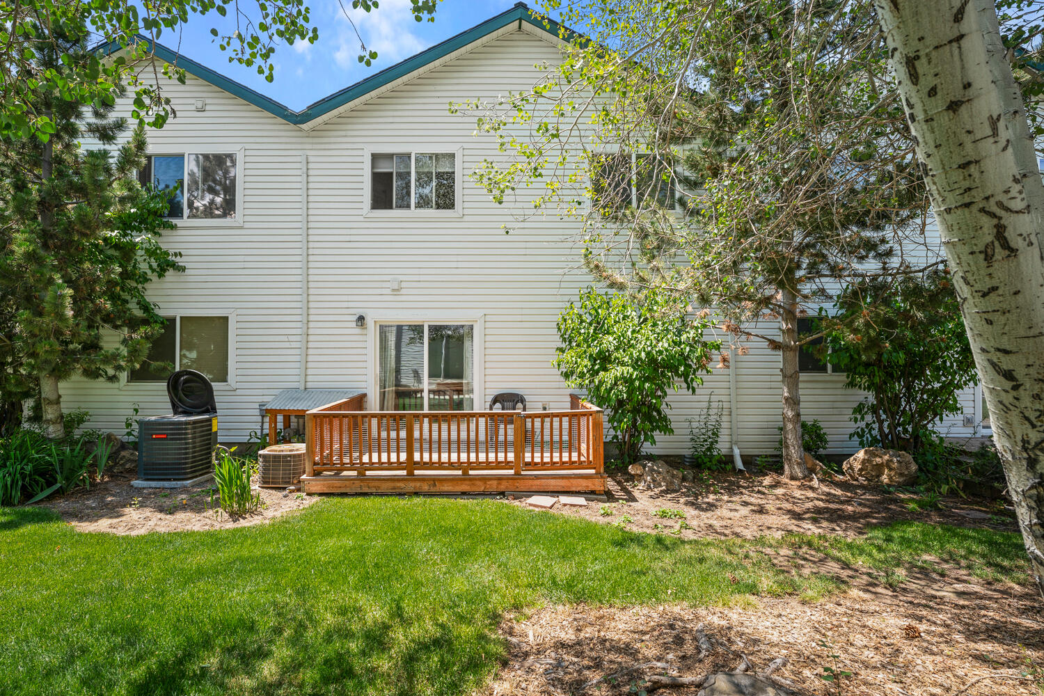 This centrally located townhome has room to stretch out and updates where they count. Upstairs, the kitchen features granite counters, updated appliances, and new flooring. A gas fireplace anchors the open living space, flooded with natural light, and the front deck offers a sunny perch to relax, take in the 180 degree sunset and sky views and listen to the birdsong. Downstairs, the primary suite opens to a private deck and community greenspace, with dual closets and an ensuite bath. A third bedroom and two-car garage round out this ready-to-go home. The landscaped community includes a pond, walking paths, and a gazebo. HOA DUES COVER WATER, SEWER, LANDSCAPING, ROOF, SIDING, PAINT, DECKS, and management.  Very low garbage, electric and gas bills contribute to a very affordable lifestyle here. Low maintenance living, with a little extra charm!