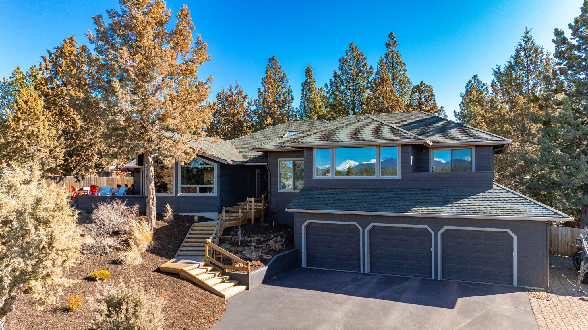 Perched on a bluff at the foot of Awbrey Butte, this newly remodeled home blends modern sophistication with thoughtful design. Stunning Cascade views enhance the open, airy layout, where no detail is overlooked—from the living room's walnut mantle to the vaulted dining space and fully redesigned butler's pantry.  
At its heart, the gourmet kitchen features honed Carrera countertops, Thermador appliances, a custom walnut island, and a newly added beverage bar for effortless entertaining. The spacious primary suite boasts a reconfigured layout, while the luxurious bath offers custom walnut cabinetry, heated floors, and a freestanding tub.  
Outside, enjoy a redesigned yard with a pickle ball/basketball court, fenced backyard, sauna, treehouse, zipline, and a heated custom-built she-shed. Mature pines and lush landscaping complete this serene oasis.