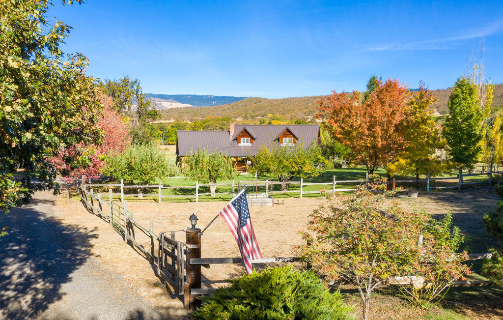 Welcome Home! This immaculate close-in rural property has so much to offer. There is a gorgeous home with quality throughout, including hardwood floors, open and inviting kitchen and incredible natural light. There is a main level master with an adjacent office space & additional half bath. Upstairs has two additional bedrooms – both oversized and one with a private balcony, adjacent sitting room and office nook. Extensively tiled full bathroom. Gorgeous irrigated pasture, fenced/cross fenced. There is a seasonal creek running through the property, a charming barn, detached oversize two car garage plus an attached two car garage. There is a wrap around front porch and expansive deck around back. Incredible views in nearly every direction. This home sits nicely off the main road so it's peaceful, serene and really quite private. The property is fully irrigated combination of Hill Creek and TID. Strong well per owner, holding tank & UV Filter.
