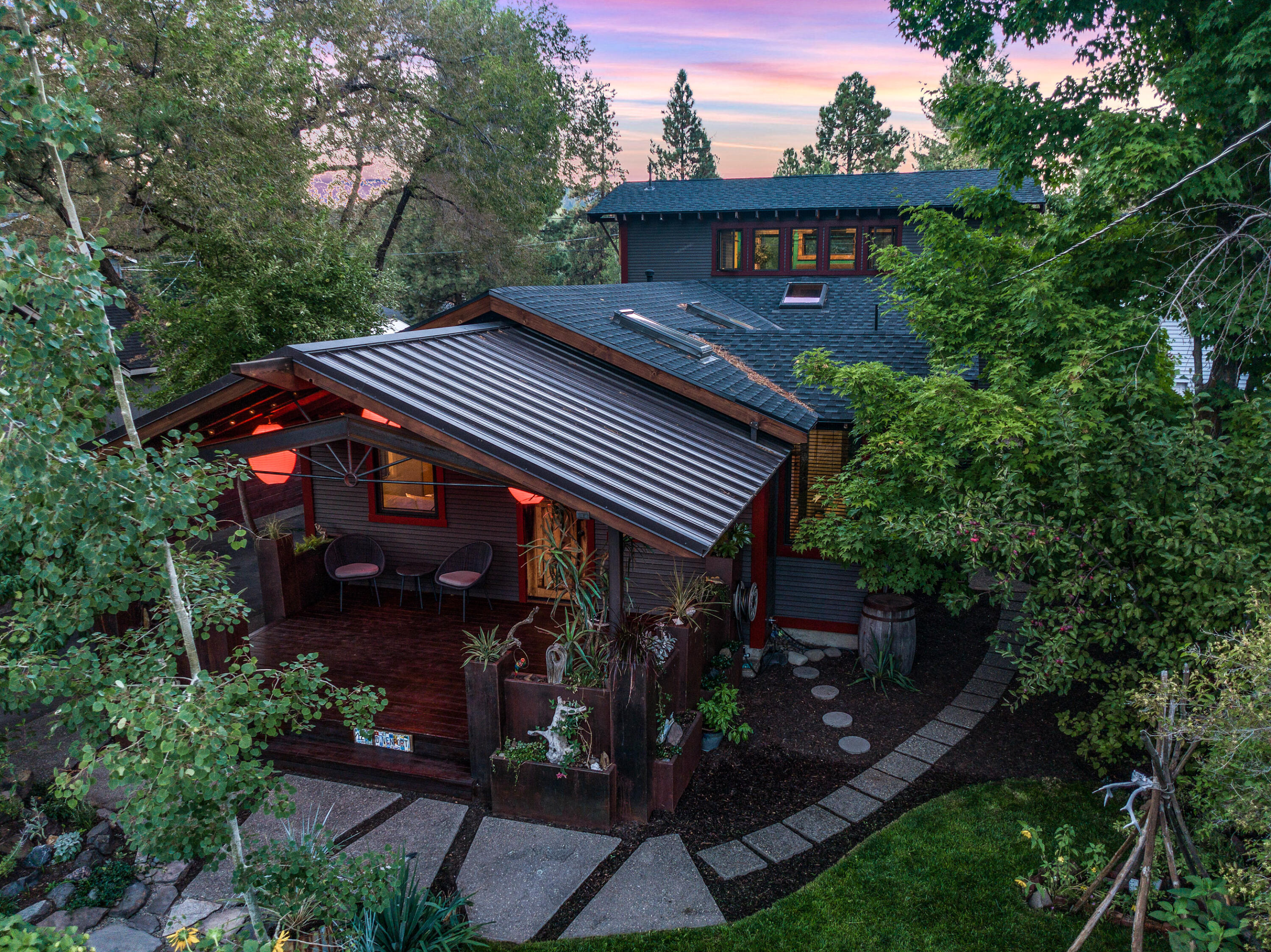 An absolute must see oasis on Bend's West Side just minutes from the river, incredible dining, & entertainment awaits! This true quality Craftsman home is artfully updated using reclaimed material from Bend mills & other sources.  Enter through a covered patio & Dutch front door, bringing the outside in w/garden views from every window.  An open floor plan with teak floors throughout, skylights & 3 bedrooms, full bath & laundry on the main level. The 2nd level is a Primary suite, a sanctuary in every way.  Surrounded by windows, natural light, walk in closet, bathroom & additional storage-built ins. The one car garage has an additional 400 sq ft attached room that can be used as a gear room, shop, or bonus room. An incredible outdoor covered patio, floating artistic metal fire pit, & hot tub create a unique outdoor space for entertaining. You will love the convenience this property offers to the Old Mill, Amphitheater, & Galveston/Newport restaurant & the Deschutes River.