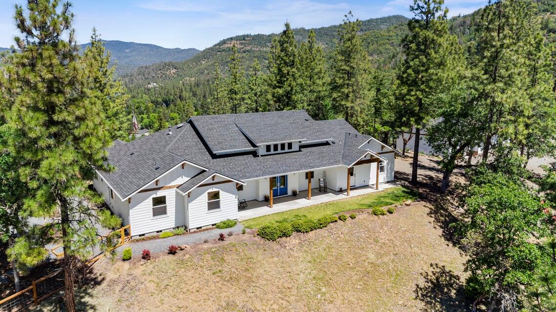 Absolutely stunning Michael Susi quality built home on 15 private acres with panoramic mountain and Rogue River views, minutes from town. This 4 bed + Office 3101 sf home is the epitome of luxury with quality contemporary finishes throughout. Master En-Suite features His and Her private vanities, built in steam sauna, soaking tub, beautiful tiled shower, oversized luxury closet and laundry room exactly where it makes sense. Gorgeous open kitchen with plenty of storage, island with prep sink, private butler's pantry with prep sink, secondary fridge and more. Outside is a finished 3 car garage with attached Legal ADU, currently used as a gym with it's on private bathroom. (kitchen and flooring needed to finish to use as living facilities). Enjoy the peace and quiet on your covered back patio with outdoor entertainment area featuring linear fireplace , TV and fans, koi pond, fenced garden areas, park like setting with your own hiking trails and more. All this AND Amazing Internet