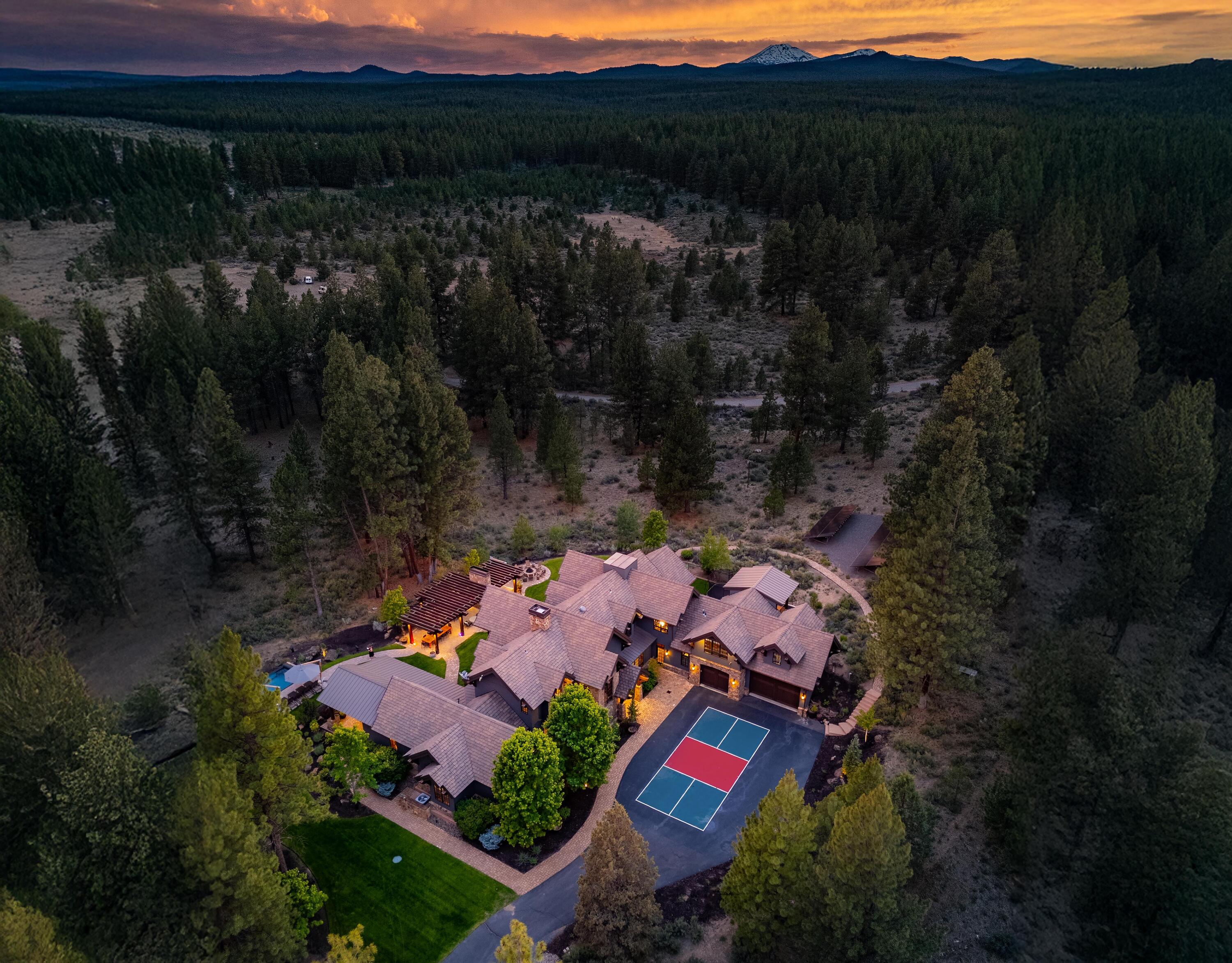Discover luxury and tranquility on 10 acres in the gated Highlands community on Bend's Westside. This 5BD, 5.5BA custom estate spans 6,772 sq ft, and has been reimagined to blend mountain elegance with modern style. Vaulted ceilings, Montana mossy rock fireplace, and beam work add warmth and character. The chef's kitchen opens to light-filled living spaces with accordion doors for seamless indoor-outdoor flow. The main-level primary suite is an oasis, and upstairs offers guest suites, a media room, and bunk room. Enviable outdoor living features a pavilion with full kitchen, grills, pizza oven, MAK smoker, wet bar, firepit, and all-weather sound system. Enjoy year-round fun in the high-efficiency Modpool with a window to the Deschutes National Forest. A true all-ages playground with pickleball court, fenced play area, and access to Phil's Trail. Smart features include Control4, solar, EV charger, battery backup, and SPAN panel. A rare chance to own the pinnacle of High Desert living!