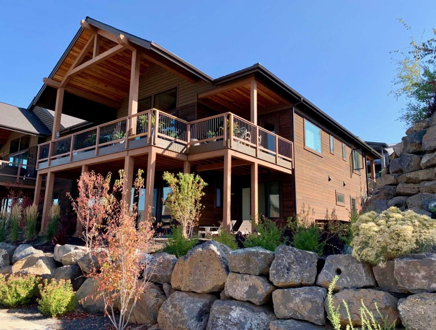 Stunning two-level Tripleknot townhome with panoramic views of the Cascade Mountains and the award-winning Tetherow Golf Course. Designed in Northwest contemporary style, this light-filled residence has vaulted ceilings on the main level leading to an open great room anchored by a sleek gas fireplace. Four bedrooms and four and a half baths ensure plenty of space with two Masters (walk-in closets & ensuite baths), two additional rooms and baths, a dedicated office, full sized laundry and storage areas. Three of four bedrooms access the rear deck or patio to enjoy evening sunsets. The gourmet kitchen includes a large center island with breakfast bar, abundant cabinetry, walk-in pantry, and premium Sub-Zero refrigerator. Downstairs includes a custom wet bar with wine refrigerator, reclaimed wood, second gas fireplace, and a media/living area with hard floors. Resort amenities include new owners' pool and Tetherow's world-class golf, dining, fitness, trails, and community events.