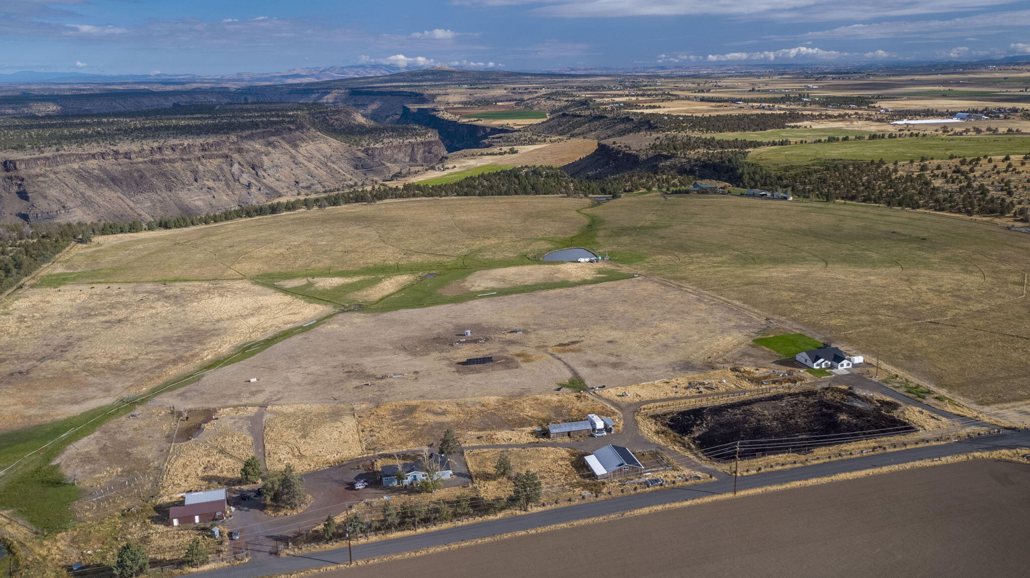 Almost 40 acres of spectacular views of the Cascade Mountains. Surrounded by beautiful farm ground the 3bd, 2bth stick built home was built in 2021. Located a good distance across the S. end of the property is a 3bd, 2bth doublewide home built in 1986. The riding arena is approx 250' by 155'. Next to the arena is a cute 4 stall horse barn with a tack room. On top of the barn is the property's solar system. A shed with additional stalls and turnouts is located to the north of the horse barn. The shop is approx 65x30 and has a meat processing room. Homes on Deschutes Valley Water from Opal Springs. 37 ac of N. unit irrigation rights makes this property highly productive for various crops or pasture for livestock. Most is under wheel line irrigation. A large irrigation pond that is stocked with bass adds to the aesthetic views.  Minutes to: Lake Billy Chinook 16, Madras 22, Redmond 25, Bend 50. 2nd home is an accessory farm dwelling. Buyer to do their own due diligence on conforming use.