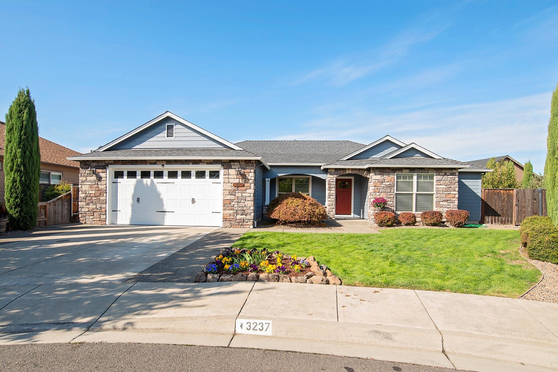 Make this East Medford beauty your new home! Located on a cul-de-sac near shopping & schools, this 4 bedroom, 2-½ bathroom home has so much to offer. From the inviting front porch space, you will be spoiled by the year-round views of Roxy Ann. You are greeted in the entry by soaring ceilings, Hickory hardwood floors & a nice, open dining/great room area. The home features a split floor plan with 2 bedrooms on each side of the home. The large master suite comes with coffered ceilings, heated tile floors in the bathroom, double vanity, a walk-in shower, jetted tub, & a good-sized walk-in closet. You'll enjoy cooking in the spacious kitchen with a gas stove, granite counters, ample cabinet space & a pantry. The outside space boasts a private patio with an electric retractable awning, fruit trees (apple & cherry), a large lawn area & raised garden boxes. Recent updates include: professionally painted exterior in 2020, recently replaced water heater and dishwasher.