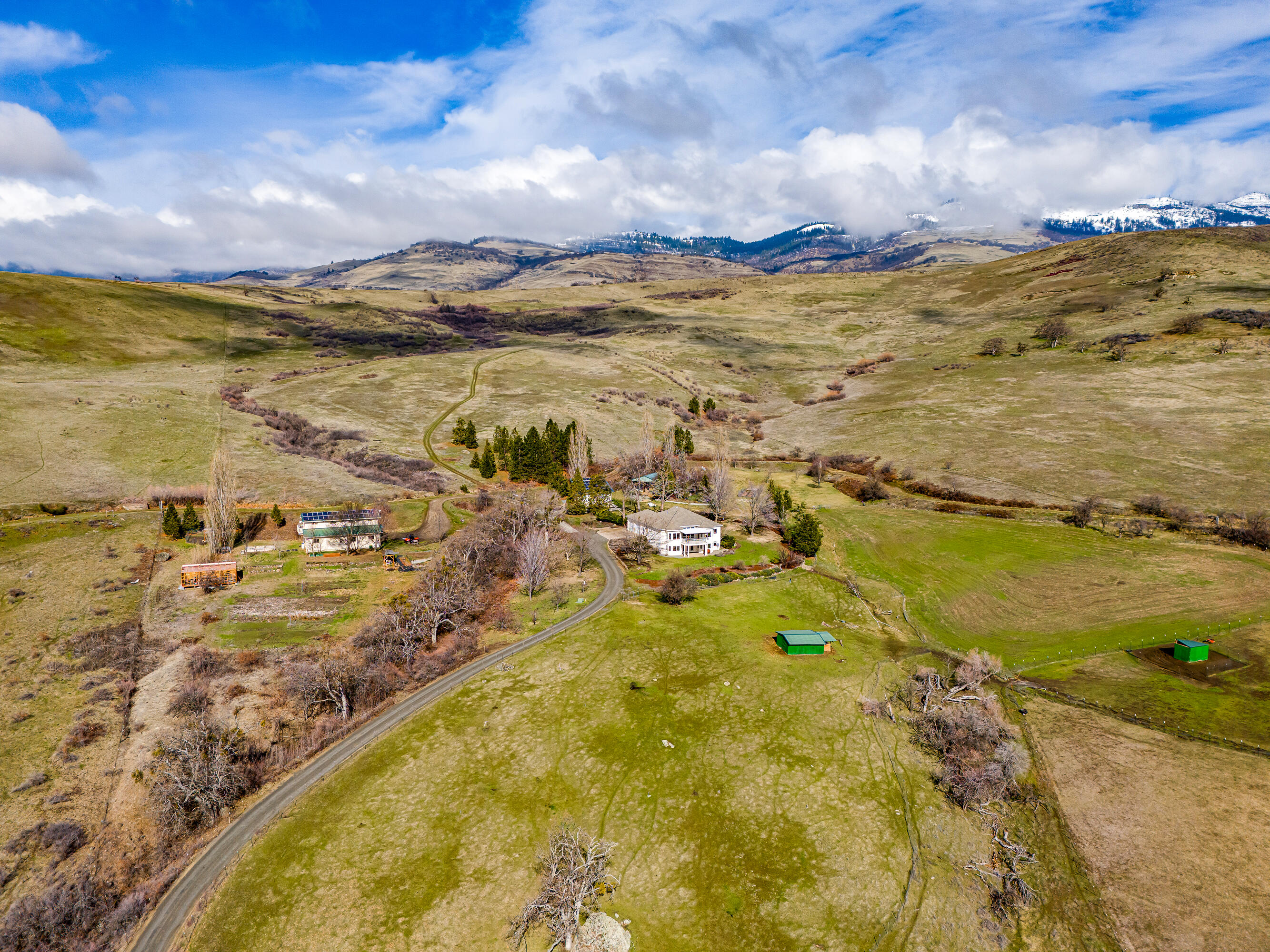 Very private ranch estate with rare potential two-family setup built by Asher Homes on serene acreage in the foothills of Grizzly Peak - just 10 minutes from town! Main home with panoramic valley views, high ceilings, living room, great room, formal and informal dining, spacious kitchen, half-bath, laundry room, covered deck, two-car garage, main-level primary with full ensuite bath, lower family room, covered patio, two bedrooms, and full ensuite guest bath. Fully permitted detached barn converted to finished living area with kitchen, half-bath, laundry room, living and recreation room, bedroom, office, full bath, separate septic and water filtration, 9 kW solar array, and 720 SqFt shop. Greenhouse, pole barn, and detached two-car garage with additional 13.5 kW solar array. Irrigated, fenced, and cross-fenced usable acreage with southern exposure. Contiguous parcels make up over 975 acres of undeveloped rural land - more than half owned by the City of Ashland. Inquire for details!
