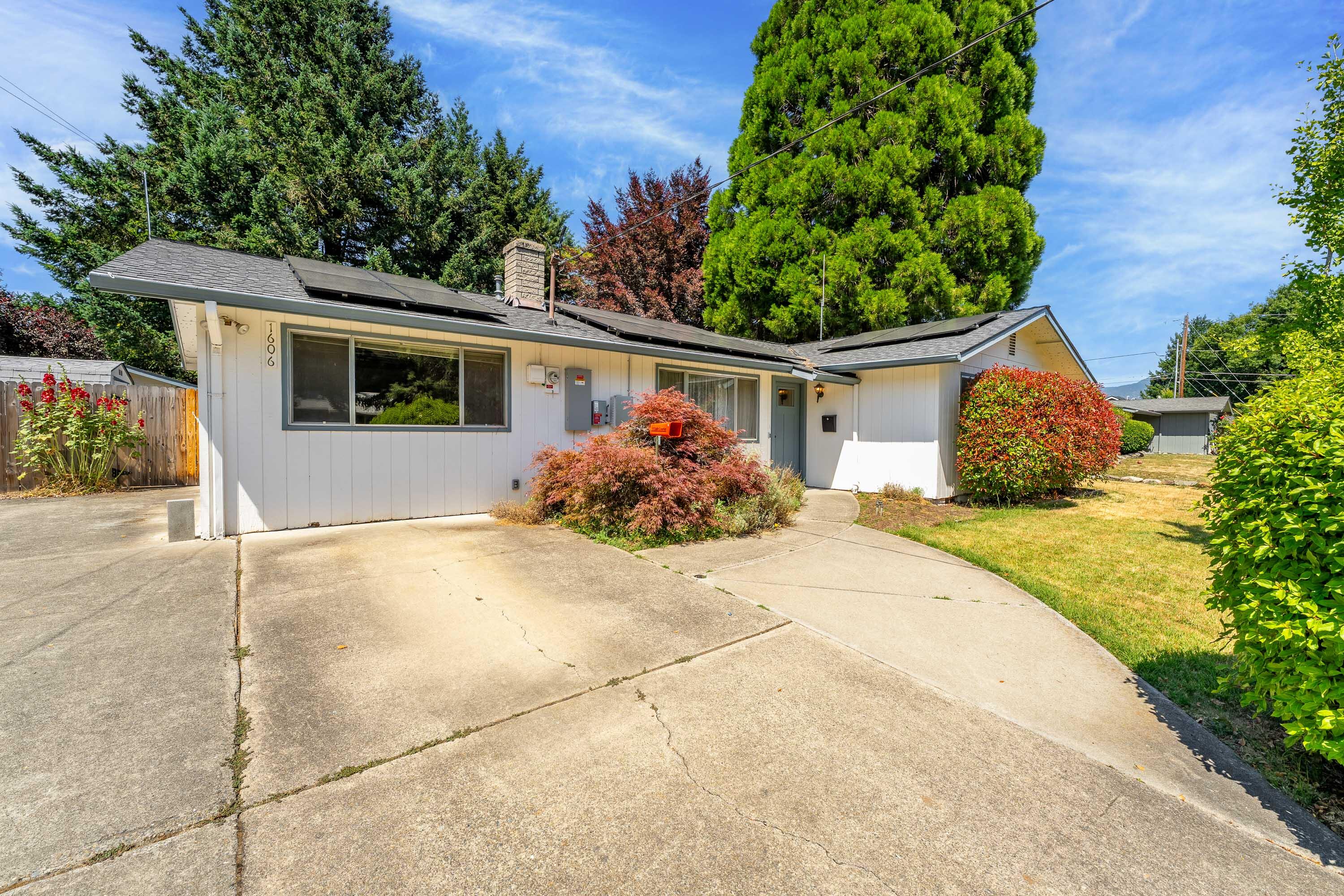 Discover 1606 Heather Dr! A well maintained for single-level home in a peaceful, desirable Grants Pass neighborhood. This spacious 3 bed, 2 bath home features two large living rooms filled with natural light, offering space to relax, entertain, or create a flexible layout. The kitchen offers ample storage and is conveniently located near the dining area for easy everyday use. The home includes two full baths and a functional floor plan throughout. Outside, enjoy a fully fenced backyard with mature landscaping, a gazebo, and two storage sheds. Located right next to the beloved All Sports Park and just minutes from shopping, schools, and the Rogue River. The seller is offering a $10,000 carpet allowance with an acceptable offer. Additional features include central heat and air, a newer roof, brand new solar panels, and a converted garage that provides extra living space—ideal for a home office, guest room, or hobby area. A great opportunity—schedule your tour today!