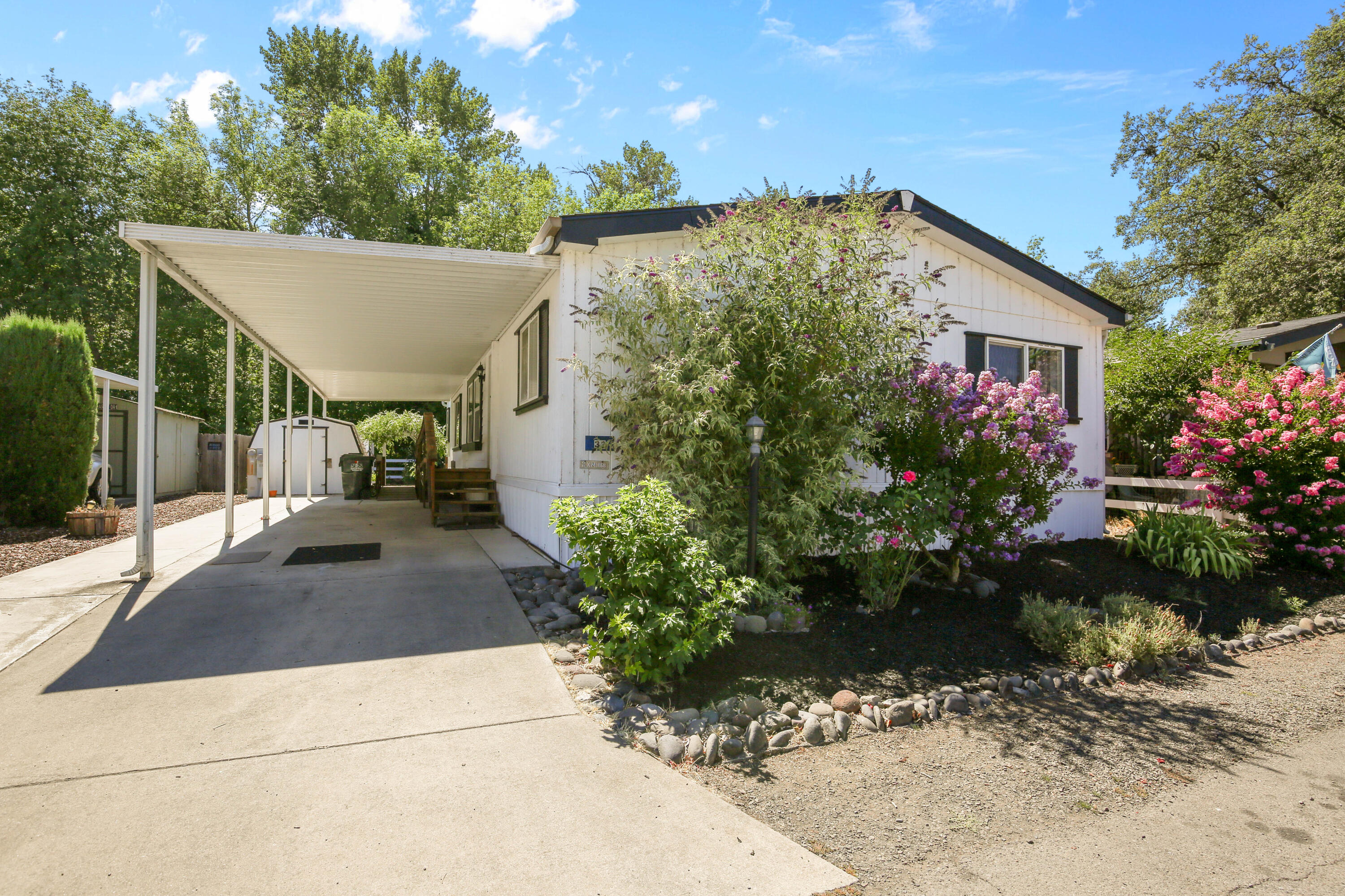 Looking for low-maintenance living in a peaceful 55+ community near the scenic Rogue River? This spacious 3-Bedroom, 2-bath manufactured home in Paradise Park II features an open layout, large den, built-in dining hutch and desk, two storage sheds, covered deck, raised garden bed, new floors, updated paint, and covered parking with both ramp and stair access. A comfortable home with thoughtful extras- don't miss it!