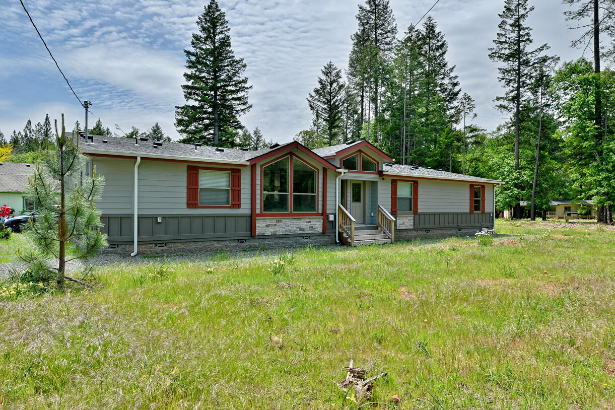 Beautiful 5.01 acres in a desirable neighborhood boasting a new 2023 custom-built triple-wide manufactured home.  Various custom features include the kitchen, living room, and bathroom cabinets, built in storage and an extra large wine cabinet that can also be used for a second pantry.  There is LVP flooring, vaulted ceilings, picture windows and an office space.  The property has a bonus possible quaint ADU 2bd, 1bath, 1 car garage for additional living space. Included on the fully fenced and gated property are 2 20x60 greenhouses, a detached 2 car garage, a steel RV cover and a spacious fenced in garden area.   This property is fully functional with a well, septic and public utilities.  Garden areas, established natural foliage and flowering plants are absolutely stunning! Schedule your showing today!
