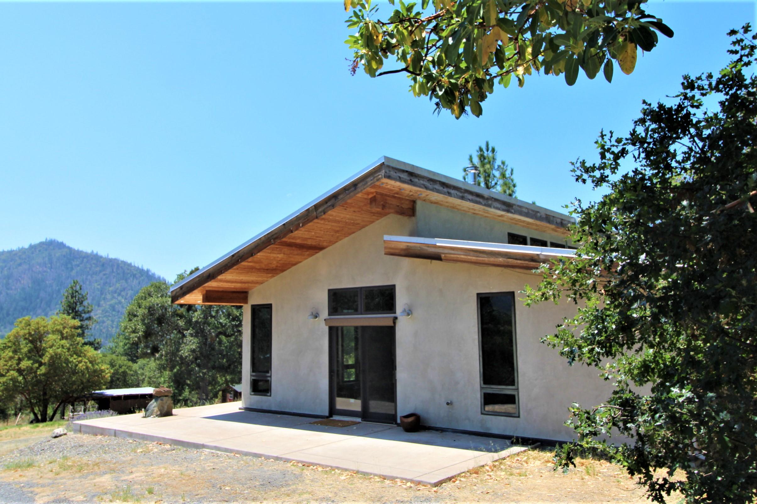Rare Green-constructed Platinum Rated Earth Advantage home w/ panoramic views situated in the heart of the Applegate Valley on 4.63  private ac. This south facing 3bd, 2bth stucco home was blt w/saving energy & occupant health in mind, using non-toxic finishes. Energy efficient SIP construction w/ passive solar design; clerestory windows offer passive ventilation. Hydronic concrete floor heating along w/ soapstone Scan Andersen wood stove offers comfortable winter heat. High-performance Low-E windows & Fir doors throughout. Kitchen features high quality, energy efficient appliances, granite counters & custom cabinets. Pleanty of outdoor patio & deck space w/ easy access from living room/kitchen areas. Split floorplan offers private master suite w/ slider to patio, tiled dual shower & low flow toilet. Property also features 1 bd studio w/deck & hot tub. Other outbuildings includes open barn, shed, chicken coop. Grid Tied PV system 9.2 KW. Close to wineries & the Applegate Wine Trail.