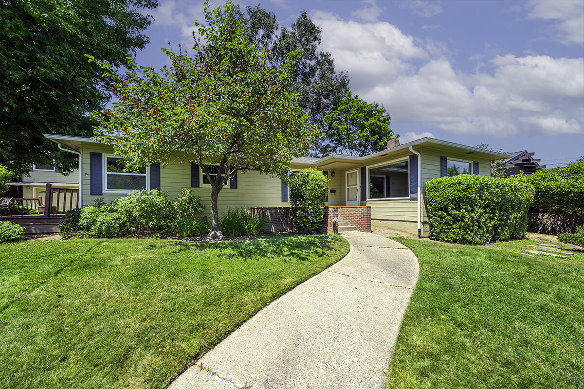 Midcentury ranch home with detached guest apartment on a large lot with mature trees located within 500 feet of Lithia Park - just two minutes from Ashland's downtown plaza! Main level living with large picture windows, custom built-in wood cabinets and window seat, fireplace with gas starter, formal dining and kitchen with solid oak hardwood floors, granite counters, butcher block dining bar, gas range with convection oven, breakfast nook, two bedrooms with closets, full bathroom with granite vanity and tub shower surround, office nook with built-ins, plus a bonus room studio or potential fourth bedroom with track lighting and sound insulation. Spacious upper-level primary suite with custom built-in wardrobes and window seat, integrated speakers, private balcony, and full ensuite bathroom with tiled vanity and tub shower surround. Detached two-car garage with renovated upper-level guest apartment complete with kitchenette, one bedroom, and full bath. Inquire for details!