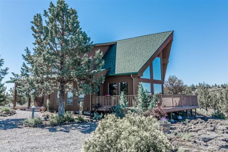 Private retreat to call home. Situated on 9+ acres adjacent to 40 acres national grass land. This chalet home offers master bedroom on main floor. Great room w/custom cabinets and large framed windows. The curved stair case leads up to a loft w/2 guest rooms. Extensive Trex decking. Hot tub + pond w/waterfall. Solar panels. 2 car garage w/shop partially fenced horse corral area.