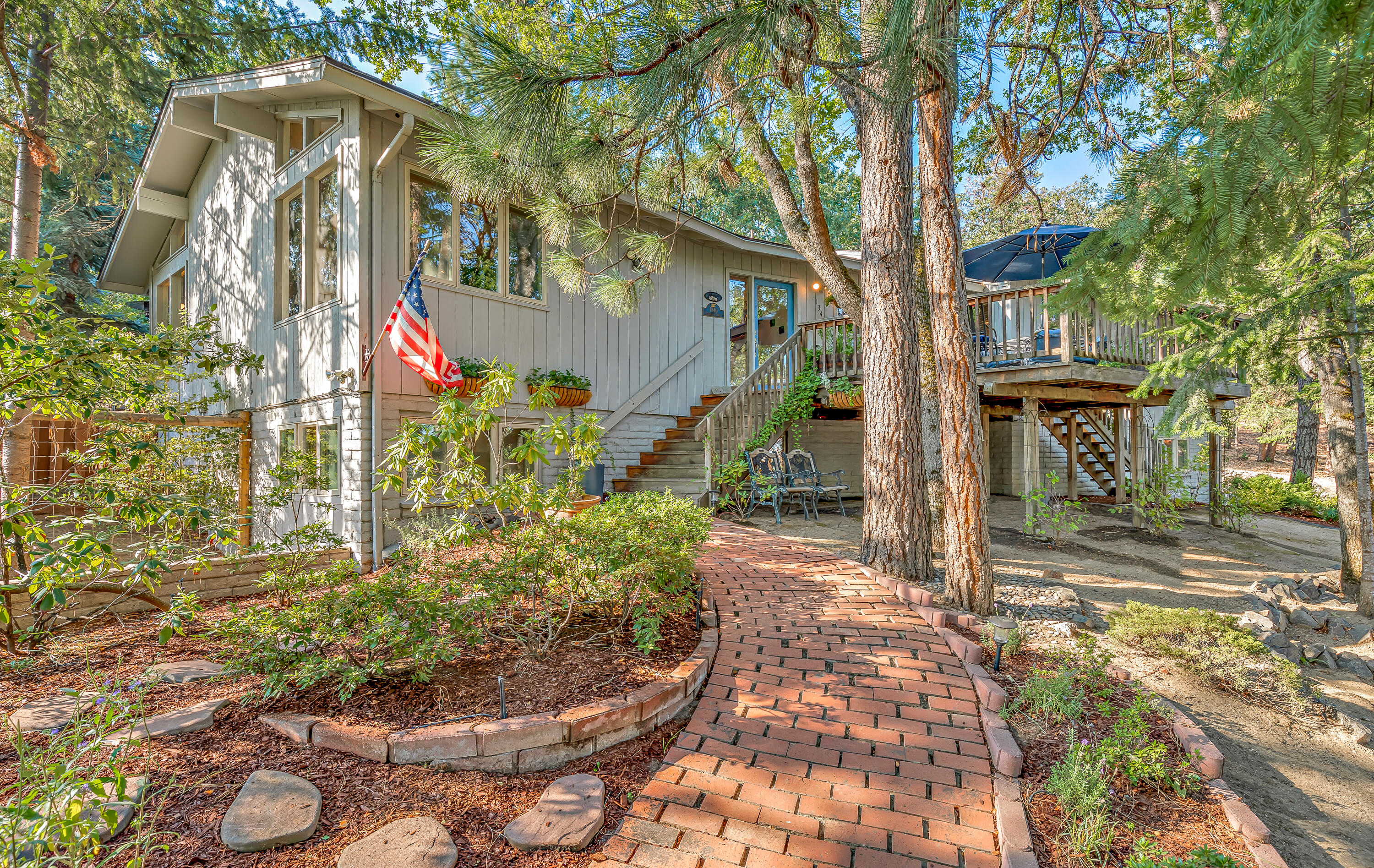Spacious and stylish mid-century home with amazing outdoor entertainment area in a private natural setting at the end of a cul-de-sac located above the boulevard with nearby access to public hiking trails, schools, and shopping! Main level features a vaulted living room with exposed beams, wide-plank oak floors, wood-burning fireplace, formal and informal dining areas, covered back deck, outdoor kitchen with gas BBQ and griddle, primary bedroom with door to backyard, walk-in closet, ensuite bath with dual vanity and soaking tub, two guest bedrooms, full guest bath, new doors and hardware, and pantry/laundry room with refinished cabinets. Lower level with two additional bedrooms, full guest bath, family room, exterior entrance from driveway with access to workshop storage area. Grounds feature mature trees and plantings, stone terracing, pathways, patio, storage shed, and new chicken coop. Underground utilities (i.e., no power lines). Inquire with agents for additional documentation!