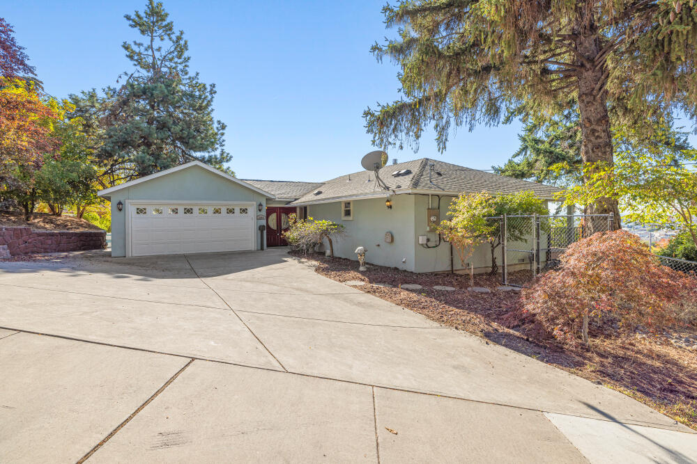 Enjoy sweeping views of the city, lake, and majestic Mt. Shasta from this beautifully designed 2-bedroom, 2-bath home—each bedroom offering its own private primary suite. An abundance of windows fills the open layout with natural light, highlighting the inviting living spaces and the stunning scenery beyond. The kitchen features granite countertops and an open design perfect for entertaining. The main suite bathroom is a true retreat with a gas fireplace, luxurious soaking tub, large tiled walk-in shower, and dual sinks. Both suites open directly to the expansive back deck—ideal for relaxing and taking in the views. The property features low-maintenance landscaping, mature fruit trees, and a greenhouse for year-round gardening. A perfect blend of comfort, beauty, and easy living.