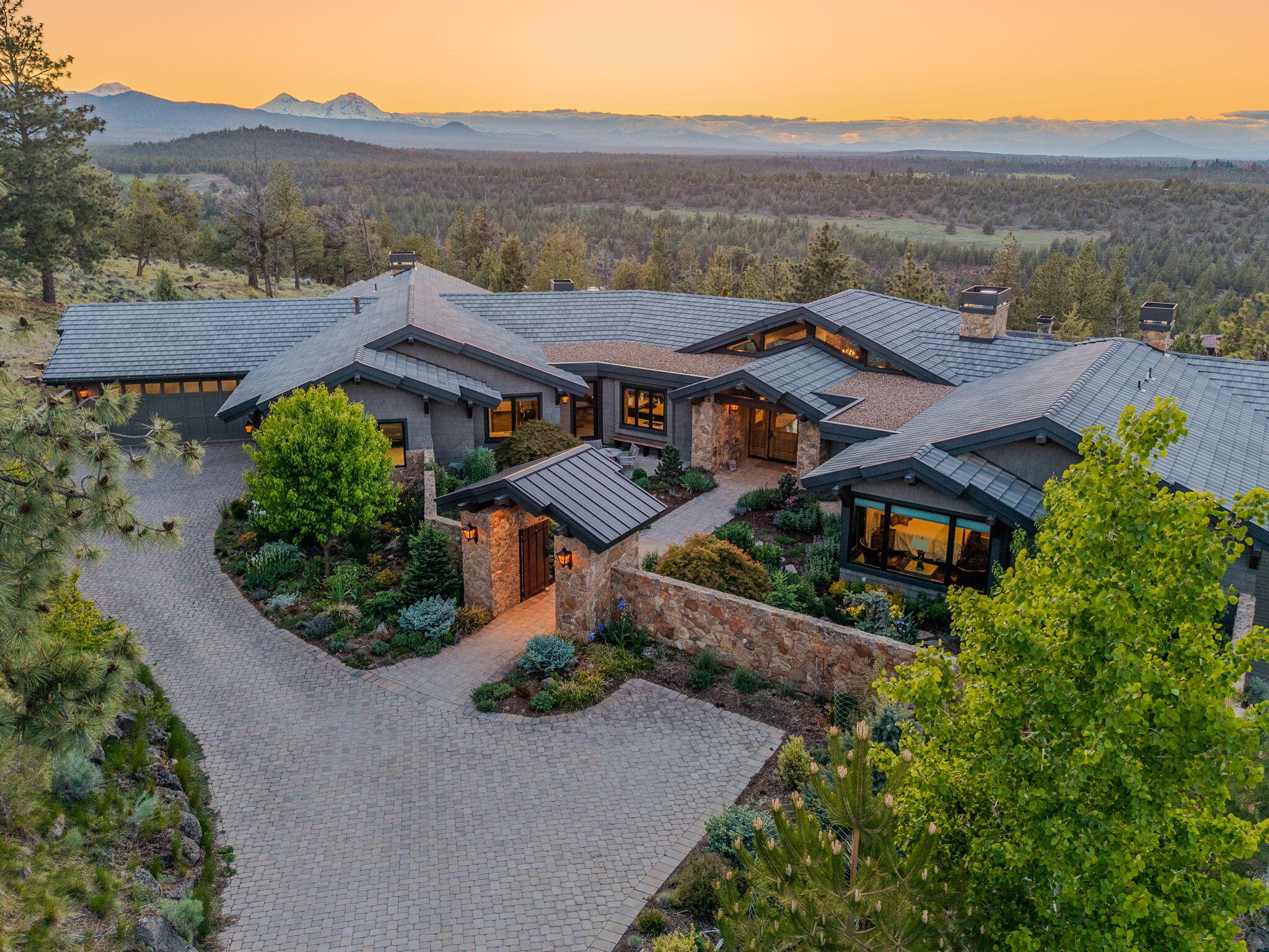 Extraordinary, single-level NW Lodge-Style retreat in exclusive North Rim. Built by Norman Building & Design, this timeless 4,515 ft masterpiece blends luxury finishes and artisan craftsmanship while capturing panoramic Cascade Mountain views from almost every room. Lushly landscaped courtyard w/trickling waterfall. Open Great Room features vaulted ceilings, dramatic wood beams, walls of glass and massive stone fireplace. Elegant dining space flows into a Gourmet kitchen w/ massive island, custom cabinetry, premium appliances and Butlers pantry. Expansive covered deck w/outdoor fireplace and fire pit, perfect for enjoying the stunning mountain sunsets. Two vaulted Primary Suites, situated on either end of the home, both feature grand fireplaces, spa-like baths, and their own private study. Spacious Guest Suite w/sitting area and separate entrance. Work out room, ample 4-car garage.  Set against a stunning backdrop of high desert beauty, this exquisite home is your dream come true!
