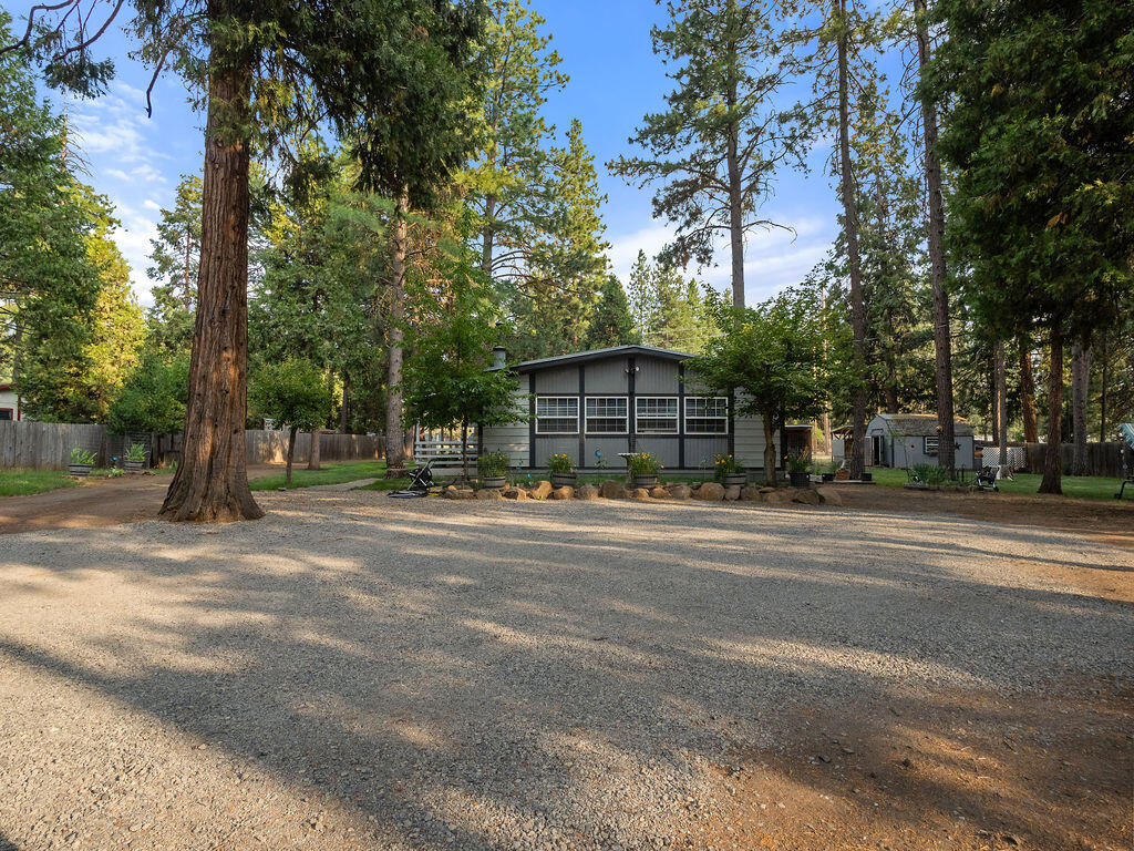 This one is the whole package! A beautifully maintained, renovated 3 bedroom, 2 bath manufactured home surrounded by filtered pines, and open field behind, great for horses or to raise your own beef!  Home has an open floor plan with newer kitchen cabinetry and counters. (Moveable island). Updated vinyl windows, floor coverings, exterior paint, and a certified woodstove insert.  Heat is gas forced-air. Home has a good-sized covered porch. There's an insulated utility/shop building, and large covered wood storage (cordwood is included). Two carports, one is tall enough for RV's.  Property is perimeter fenced and gated. Picturesque setting and only 15 minutes to town!