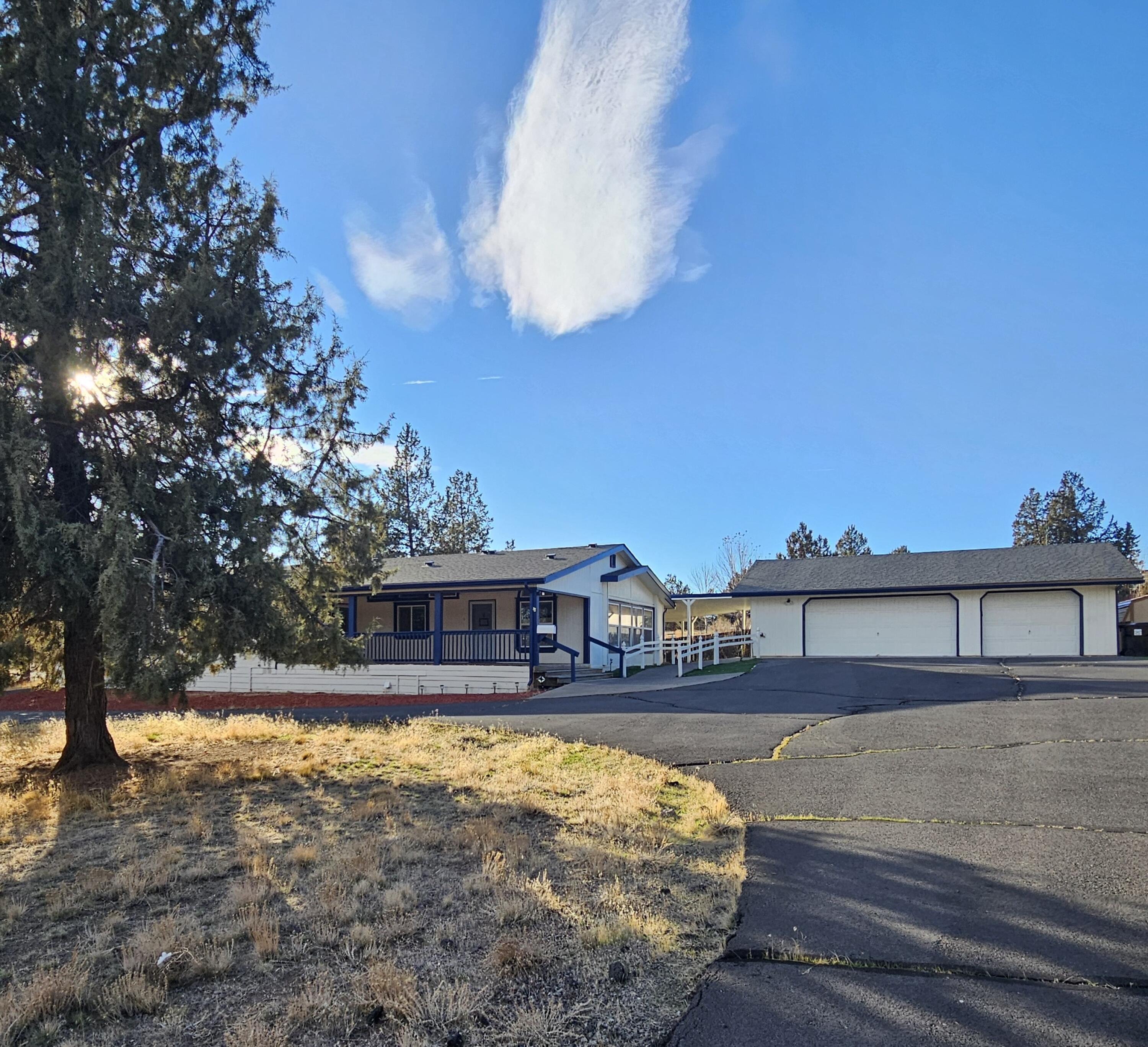 Affordable living opportunity in Crooked River Ranch! This Spacious Triplewide manufactured home features both formal and casual living spaces, a large dining room and open country kitchen with a center island, 2 wall ovens and an electric cooktop.  County records show 3 bedrooms, but a shared wall from in the primary suite was opened to the former 3rd bedroom; thus making this home 2 bedrooms and 2 full bathrooms. The primary bath has seperate his and her vanities, a soaking tub and enclosed toilet with fiberglass shower stall. Set on a spacious lot with room  for vehicles and more. There is a detached garage  which accommodates two vehicles and includes an enclosed workshop with its own restroom—perfect for projects, storage, or creative use. With solid structure and flexible layout, this property is ready for your personal touch. Sold  strictly as-is. Seller has no knowledge of property condition or permit history.