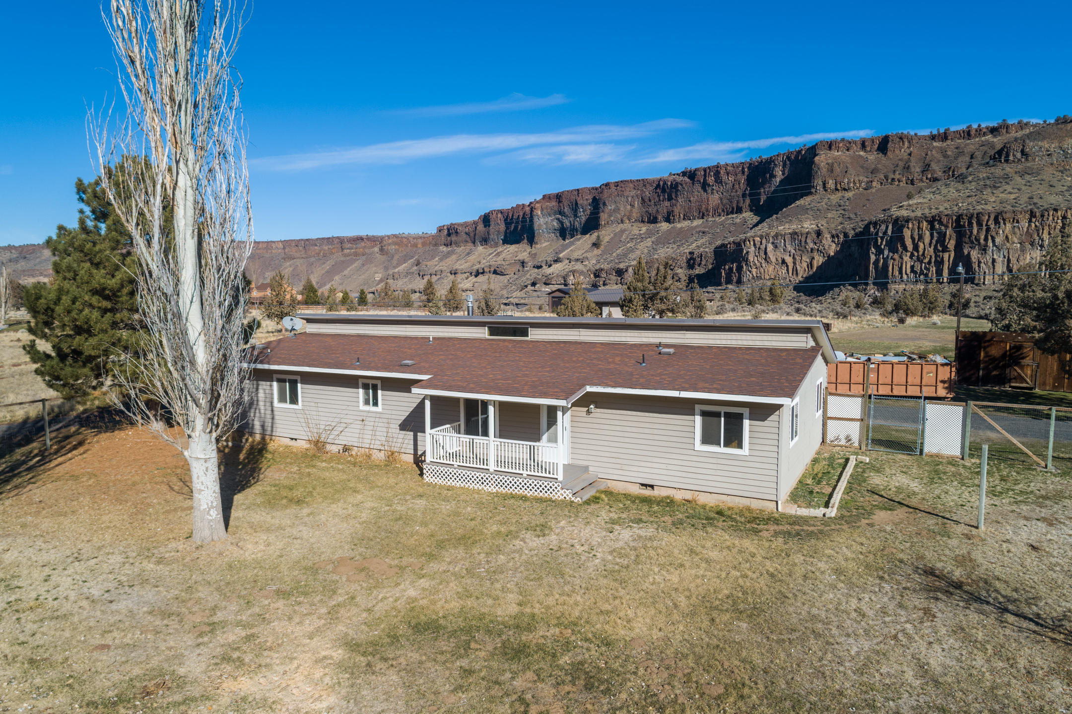 Tired of cookie-cutter homes?  Here is your chance to own a 1840 sq.ft. home with real character on 2.5-acres, in the heart of Crooked River Ranch. Master bedroom is separated from two guest bedrooms, plus large flex room would make a perfect mud-room or home office. Ceilings are vaulted with exposed rustic beams in the living room. A large stone hearth supports a cozy propane fireplace. Dry bar off the kitchen is perfect for entertaining or use as a breakfast bar. Stay protected from the elements in the enclosed sun porch, to watch the wildlife roam or bask in the Central Oregon sunshine from your fenced front yard. The beautiful 1960's two-stall barn with work shop room and enclosed hay/tractor storage still remains from the beginnings of the long history of this property and there is plenty of room to build the shop of your dreams! Property backs to public land from which you can see the Crooked River.  You won't find another home like this!
