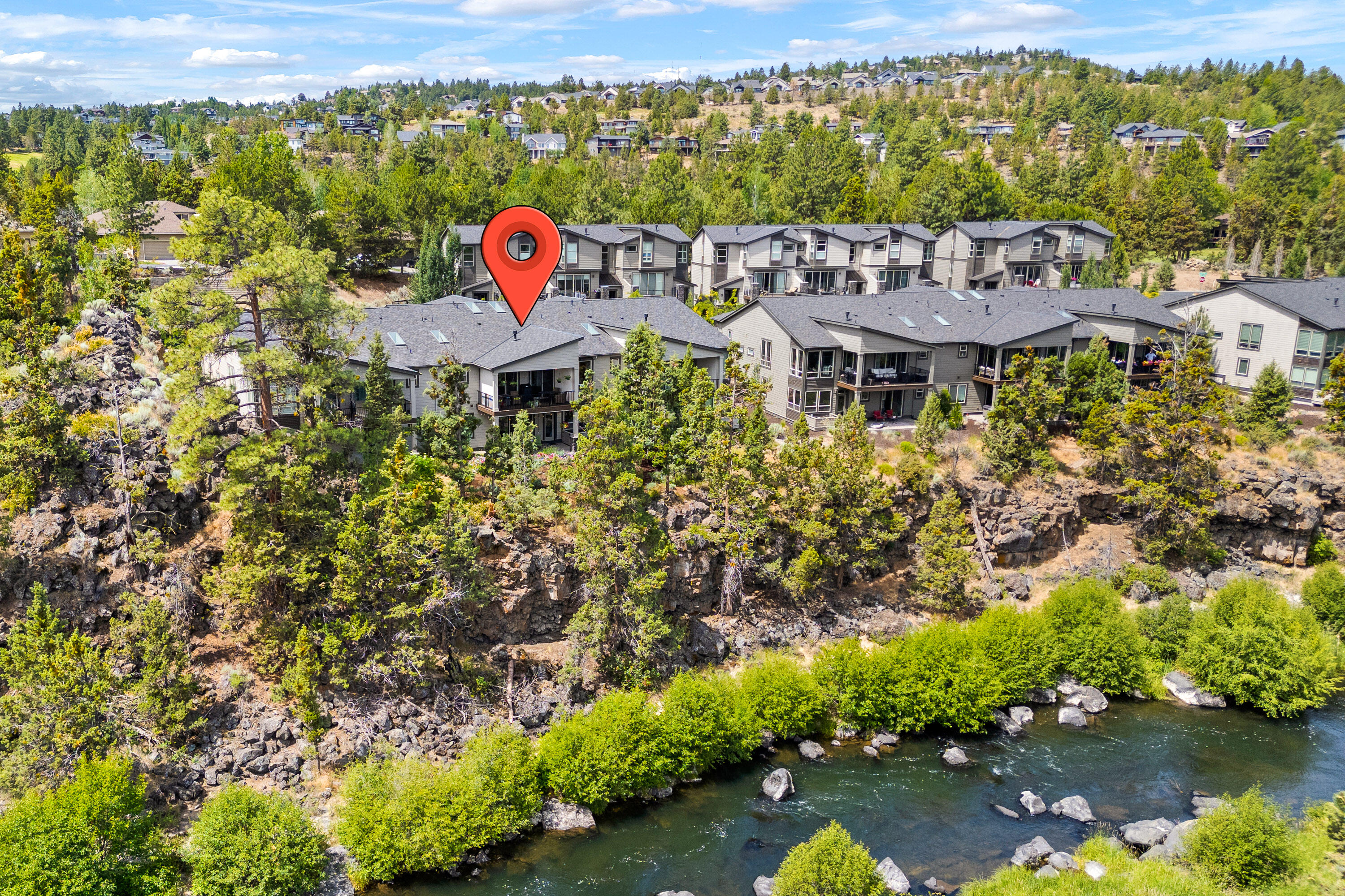 Modern Riverfront Townhome located in Rivers Edge Village. Enjoy the Deschutes River from your upper and/or lower back deck or walk out your front door and be on the Deschutes River Trail within moments. Close to shopping, parkway access and within minutes to Downtown Bend. This floor plan features main level living with plenty of space for entertaining, and a gourmet kitchen with an oversized island. The large primary suite on the main level has a floor to ceiling tiled shower, dual vanity, soaking tub, large walk in closet and motorized roller slider shade. The main floor offers a home office/den and an expansive Great room with gas fireplace and built in cabinets. Downstairs  has an additional guest suite, an additional bedroom & bathroom with a bonus room including a wet bar. In addition to the downstairs laundry room, you also have a stackable washer and dryer on the main level. New carpets in all the bedrooms installed last year. Lots of extra storage above and below the garage.