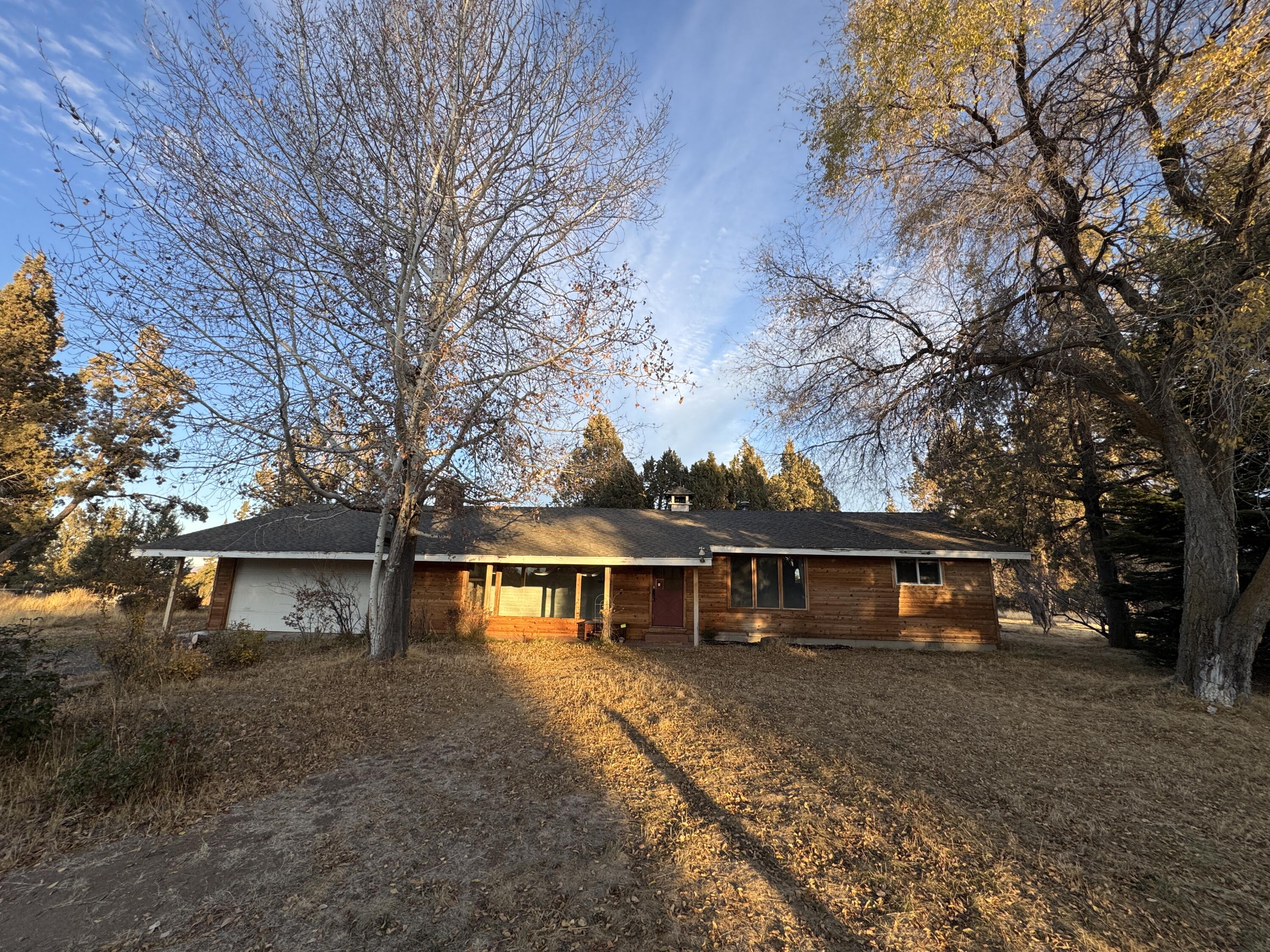 $50k Price Reduction! Charming Country Retreat w/Views, Irrigation, & Endless Potential. Discover the amazing potential w/this mostly updated single-level home located in a stunning private country setting w/mountain view, minutes from town. The property offers an exceptional blend of comfort & outdoor enjoyment. The spacious barn has concrete floors, ideal for storage, workshops, or creative projects. A large hobby building/man cave adds more versatility & space for your passions. Enjoy the serene outdoors w/private garden area, greenhouse, & multiple raised beds, plus a lovely orchard & gazebo for peaceful relaxation. Two large ponds offer opportunities for water features or simply enjoying the natural beauty. A rustic bridge crosses the canal that runs through the property. Additional features include a paved driveway, an attached 2 car garage, & full fencing for privacy & security. Surrounded by other beautiful homes & properties, the location offers both tranquility & convenience