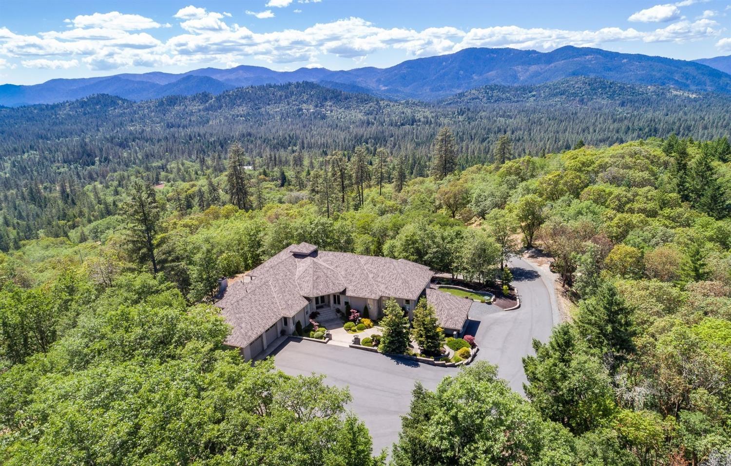 Impeccably crafted with attention to every detail, this custom masterpiece transcends the ordinary. From the grand entry to every specially chosen fixture, this 4900+ s/f, 3 bedroom/3.5 bath beauty will capture your attention & your heart. It is nestled on 11.4 wooded acres in two separate tax lots with two wells and long-range mountain views. Revel in a foodie's paradise-a kitchen outfitted with commercial grade appliances, slab granite, 2 Fisher Paykel dishwasher drawers, double ovens, split kitchen islands with separate prep sink, and a wine captain set in a gorgeous wet bar in the living areas. Superior quality is showcased in Brazilian Lyptus wood cabinets, teak floors and a unique alcohol burning fireplace, plus a master suite complete with a heated jetted tub and stunning tile walk-in shower. State-of-the-art electronics, full outdoor kitchen with fireplace on a spacious covered terrace for entertaining. Also-4 car attached garage plus 2 car carport/RV parking.