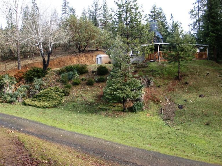 Beautiful views from this wonderful property located less than ten minutes from the Ruch Country Store! Relax on the huge covered porch and take in the pine covered hills surrounding this home. Over 2 acres that back up to BLM Land, enjoy the privacy and the easy access to the Government Owned Land. This three bed, two bath home has an open floor plan. The kitchen is light and bright with a big island for prep and seating, as well as plenty of storage and counter space. There is a nice dining area located between the separate living and family rooms. The wood stove heats the entire home with a cozy warmth, to supplement the electric heat. Recent upgrades include the beautiful laminate flooring. The Master Suite has a spacious bathroom and a large walk in closet. The front entry leads out onto the huge covered deck, which offers great views and a place to entertain in the shade. This is a great place for someone who wants a little space and privacy.