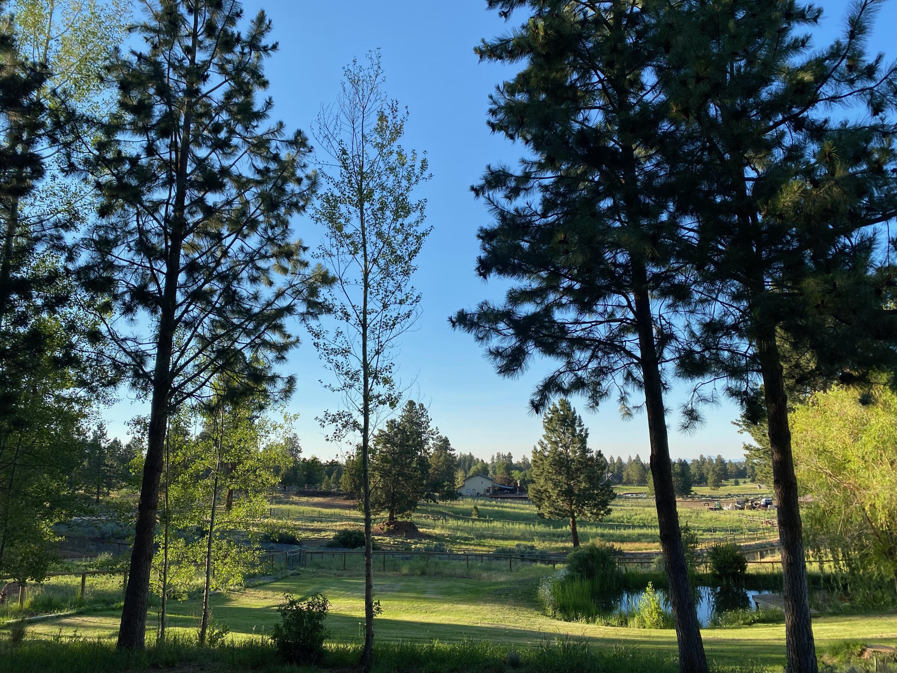 The original homestead of Woodside Ranch is located less than 1 mile from Bend's SE city limits.  The floorplan is perfect for entertaining with multiple levels, soaring vaulted ceilings, and windows that capture the outside serenity through every angle.   Recent upgrades to the house include a new expansive composite deck with LED lighting, exterior paint, wood stove, stainless appliances, contemporary lighting, water heater, garage floor epoxy, and hallway bathroom remodel.  The entire property is irrigated with new underground sprinklers on timers for ease of use. If you have animals, you'll appreciate the new 24' X 36' insulated 2 stall barn, new fence, and the ability to ride from the property to BLM riding trails.   The back of the property is lined by the irrigation canal with a gravity fed water feature on the West side of the home which drains into the pond in the front yard.  This oasis has room for a shop and/or ADU to be added to the end of the driveway by the garage.
