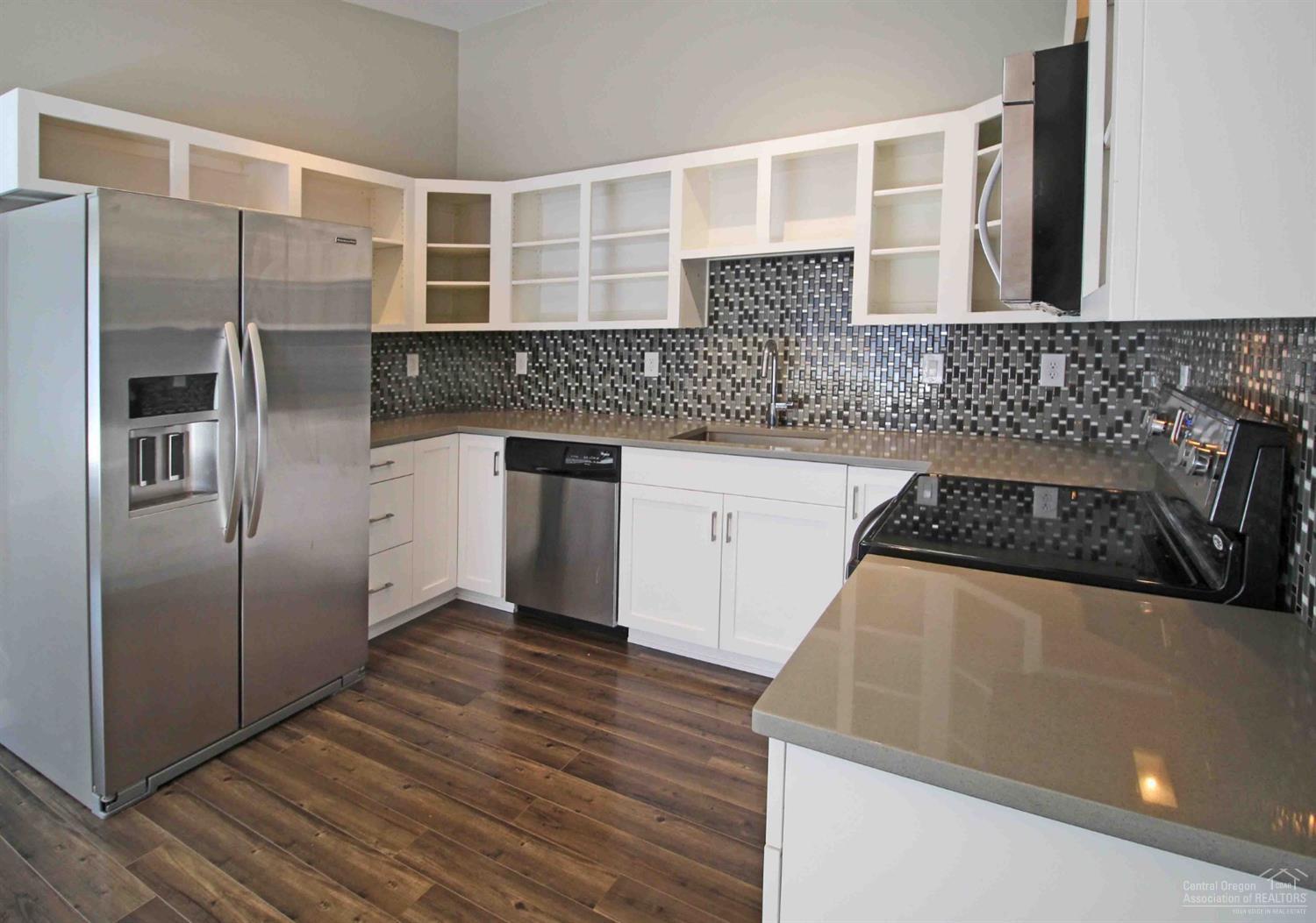 This is a feel good, move-in ready property that has been completely remodeled with a modern flare. Easy maintenance, zero lot line, convenient location and practically brand new! Kitchen and bathrooms offer gorgeous tile back splash, new cabinets/hardware, Quartz countertops and new light fixtures. Kitchen has all new stainless steel appliances, quartz countertops and new cabinets. All new Evoke laminate flooring throughout the home with tile in the lower level hallway. Brand new carpet in bedrooms as of July, 2019! New hardware on front and interior doors. New light fixtures. New exterior paint and roof in 2018. New Cadet heaters! Fenced back yard is easy care with fresh bark mulch. All appliances are being sold with the property. HOA is $25/month. Single car garage. There is a good amount of interior storage as well! This home recently rented for $1,400/month.