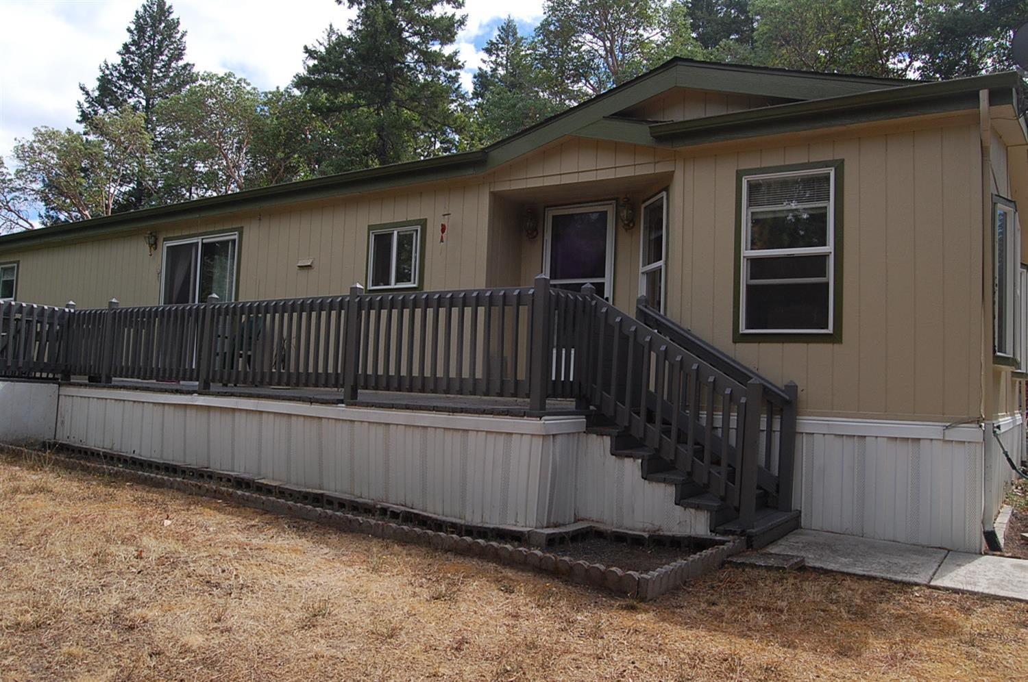 Pride of ownership shows in this 3 bedroom, 2 bath, 1716 sf double wide manufactured home with a 2 car detached garage plus carport, and lots of room to park any size RV and other toys or equipment. The home features a large kitchen with beautiful cabinetry and a big island/breakfast bar, walk-in pantry. Spacious living room with bay windows. Large master bedroom and the master bath is huge with two vanities, garden tub and walk in shower. Covered deck on front, detached 2 car garage with attached carport. Located on 6.01 acres wonderfully treed for privacy.