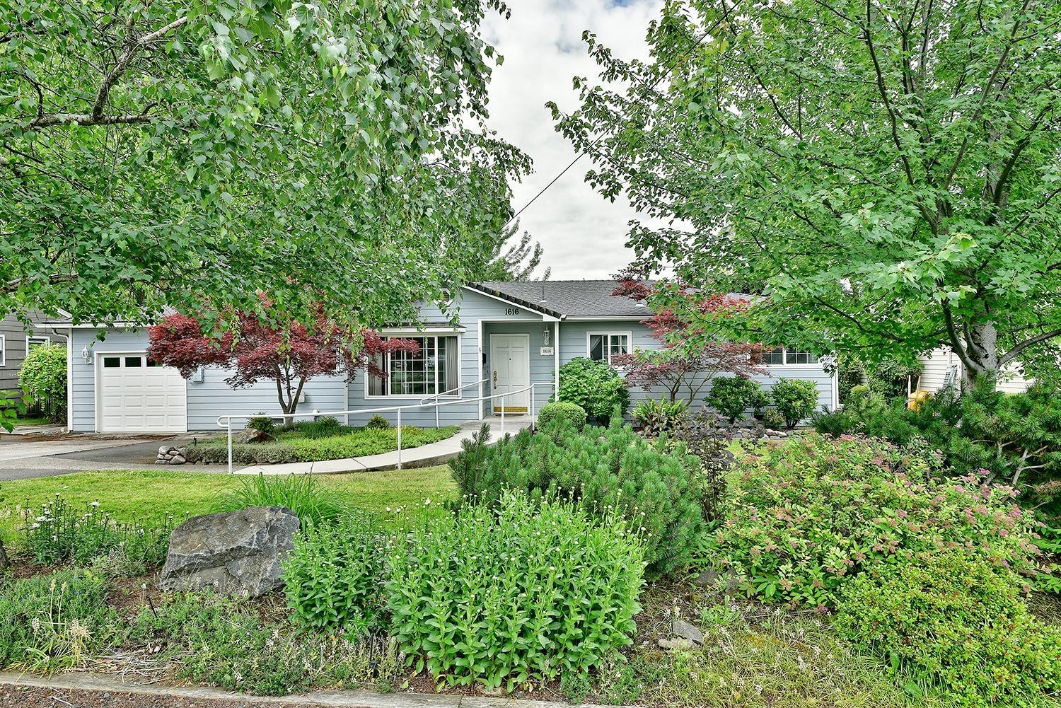 This extremely well cared for mid century home is located in a desirable East Medford Neighborhood. Home has been lovingly maintained and features charm of it's time with shiplap and open beam ceilings, hardwood floors,two fireplaces, and an abundance of built in bookshelves and cabinets. In addition this home has been updated with Milguard Vinyl windows throughout, a sky light in the kitchen, and a new insulated garage door. This home offers a tremendous amount of storage space inside and out, plus an attached finished workshop/hobby room off the garage. Outside is a large covered composite deck over a patio on the lower level. The mature landscape here is beautiful and impressive, providing for a private setting in the backyard that offers curbed lawns, and concrete walkways. One year Fidelity Home Warranty included. Call to schedule a tour of this wonderful home today!