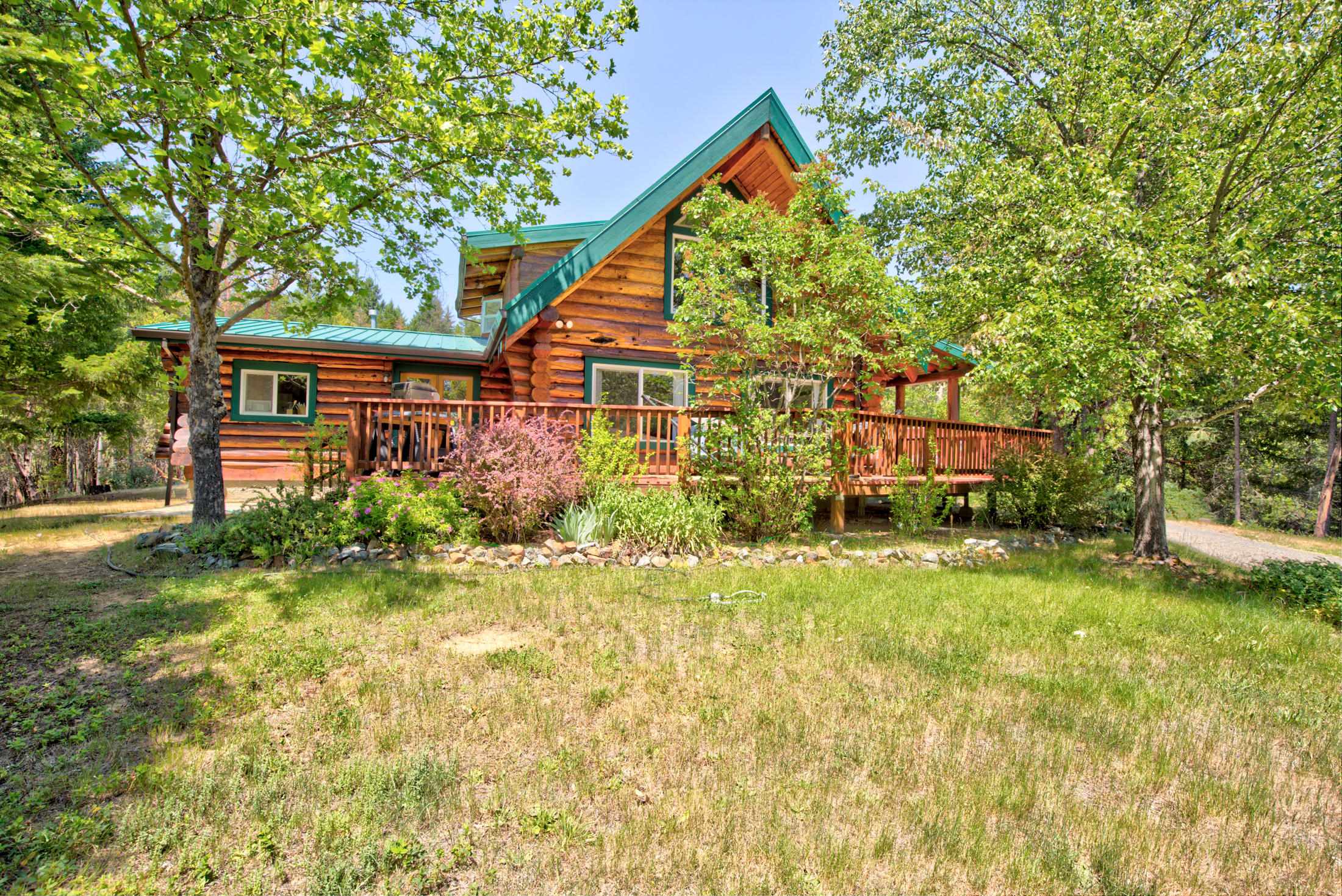 GREAT NEW PRICE! Beautiful custom home by Homestead Log Homes with metal roof, covered deck on 3 sides of lower level, & upper deck off the master. Home has 3 sources of heat; wood, propane, & ductless mini-splits To keep the home cool during warm weather. Appliances include refrigerator & washer that are less then 2 years old. The eat-in kitchen has a large pantry and convenient layout. Naturally this home has beautiful woodwork throughout & plenty of storage areas. Master has walk-in closet &  jetted tub. The property has two large water holding tanks with a very sophisticated underground watering system, garden area with electric deer proof fence, & 70' long green house. The garage is 24 x 30, totally  insulated, plumbed for a compressor, includes full bath with some work benches and shelving included and has an attached carport with electrical outlets. Fenced with electronic gate, lots of outdoor lighting & 2 RV dump stations. 1 year home warranty.  MOTIVATED SELLER