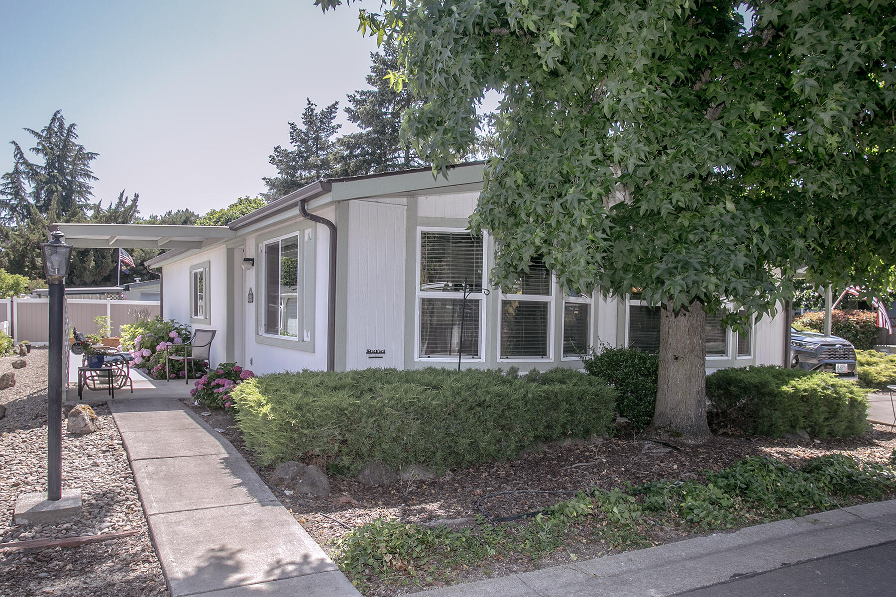 Charming home in Rogue Valley South (55+ park) that has been beautifully updated over the past few years! Recent updates include: 2021—Luxury vinyl flooring, serene interior paint, remodeled kitchen with pull-outs & coffee bar, new refrigerator/washer/dryer (included); remodeled bathrooms with walk-in showers); new heat pump. 2022—Fresh exterior trim paint. 2023—New vinyl double pane windows. 2024—Added back patio. 2025—Added two raised garden beds (10'x20'') & elevated garden bed. Bay windows brighten the spacious living & dining areas. Primary suite offers double closets & appealing backyard views. Sweet easy-care backyard with patio & planters. North-side covered front porch nestled in with lovely hydrangeas on drip system, solar lights from street to front patio. Front yard also on timed drip system. Some furniture can be included with sale. 1-year home warranty offered.