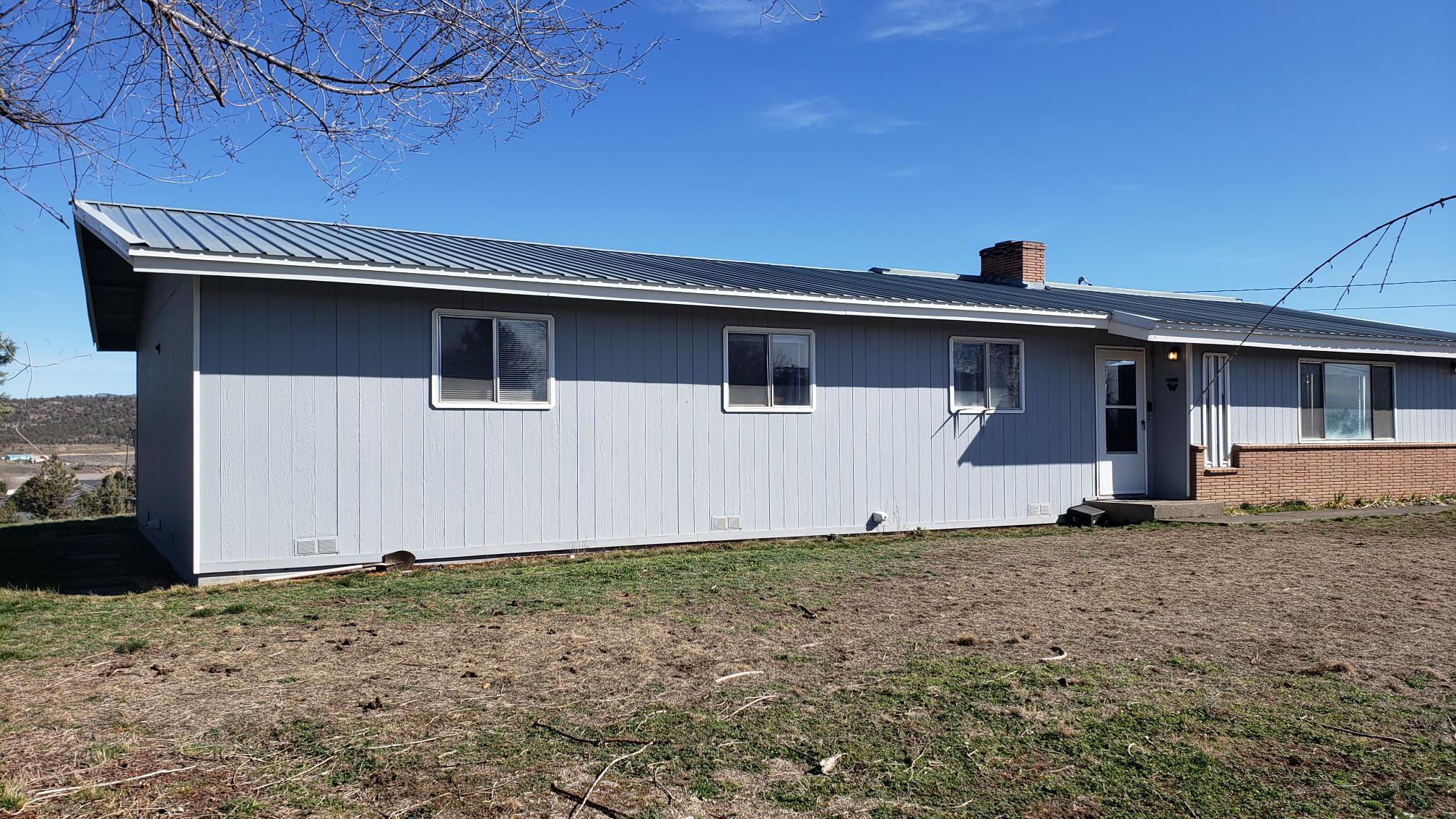 Large Lot 1.3 Acres with views of the valley, city and Grizzley Mountain etc.  Located in the city, one block from schools.  This 4 bedroom, 2 bathroom home with a living room and family room has over 2,000 sq. ft.   and lots of property for your ''toys'' or maybe add an ADU for the relative or rental.  There is a detached smaller one car garage that can be moved if needed and a smaller storage shed too.   The home was built in 1961 but had an addition completed / updates which makes the home equivalent to a home built in 1985 based on Jefferson County property profile.  This home is served by public sewer and water.   Roof is metal,  in fantastic condition.  The wood siding is in good condition, with trim and paint the same good condition.    Large patio looking east toward the Ochoco's.