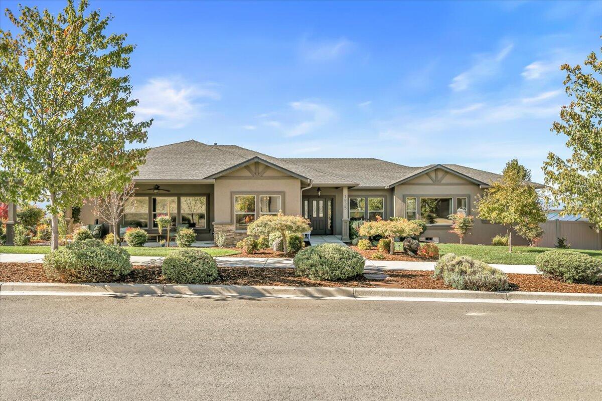 Gorgeous sunset views from this custom-built home perched on a knoll at the base of Roxy Ann! This 3-bedroom, 2-bath residence in prestigious Panorama Heights, blends luxury and comfort with warm finishes and numerous upgrades. The chef's kitchen offers a large island, granite counters, stainless appliances, and an open layout to the great room and dining area—perfect for entertaining. Large windows and a gas fireplace with stone surround create a bright, inviting space. The primary suite includes a spacious ensuite bath and generous walk-in closet with built-ins. Enjoy sunrises from the expansive wraparound front porch and the stunning Sunset Garden from the back, ideal for cookouts and gatherings. The thoughtfully landscaped, low-maintenance yard offers year-round beauty, complete with a greenhouse and fruit trees. The oversized 2-car garage with craft room & ''standing room'' crawlspace, provides abundant storage.   Come experience the charm of this exceptional home!